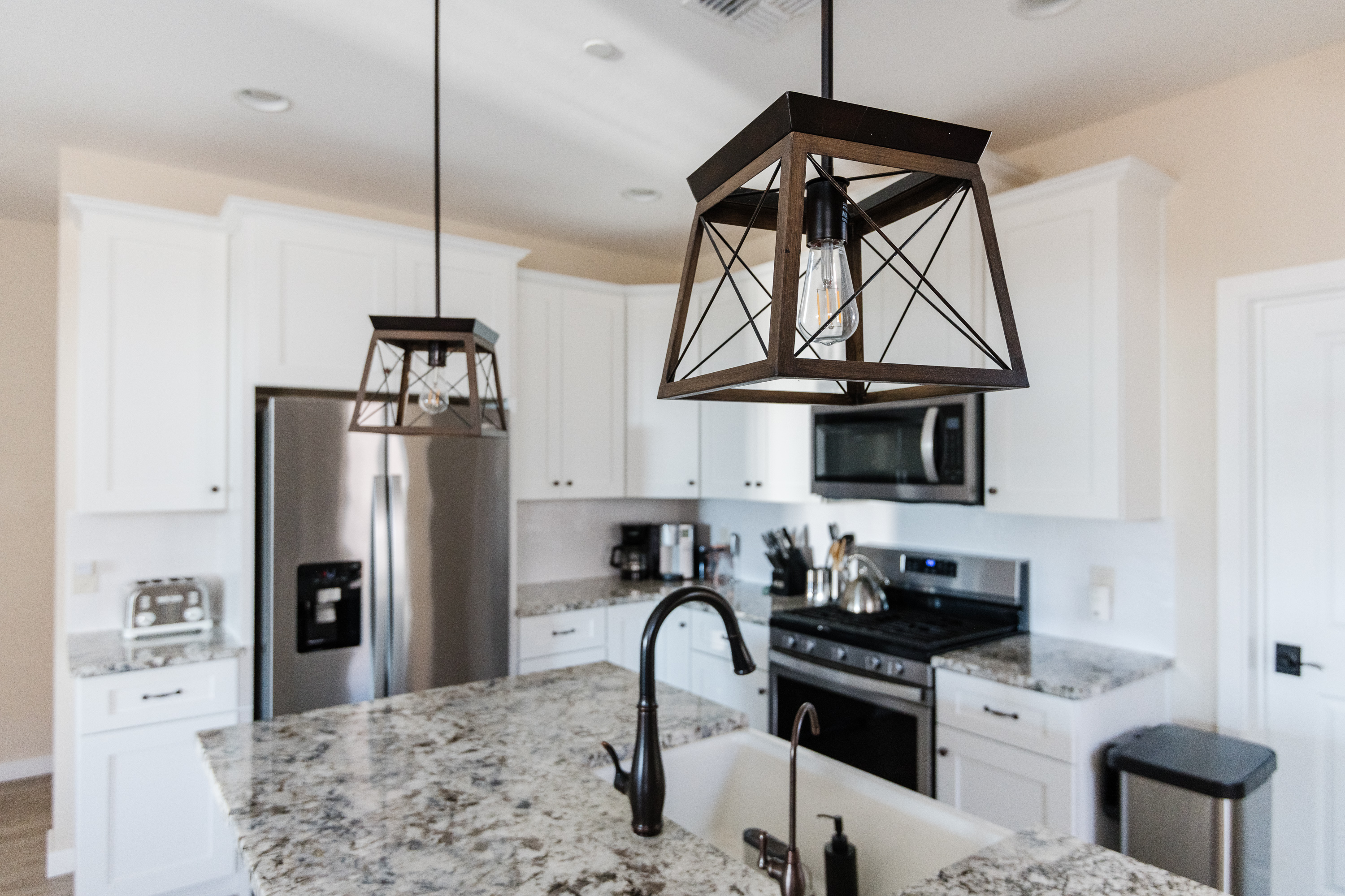 Bright modern kitchen with granite island and stylish pendant lighting