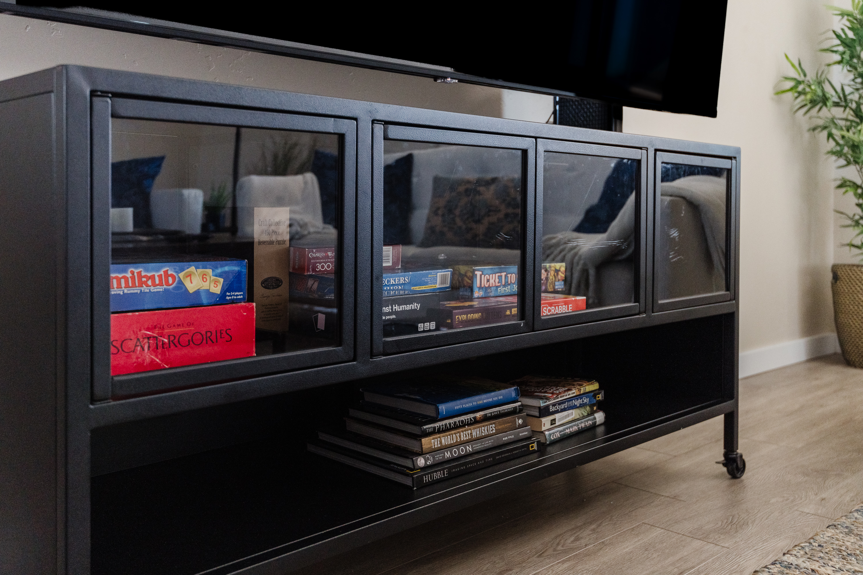 Modern media console with TV, board games, and books for cozy nights in