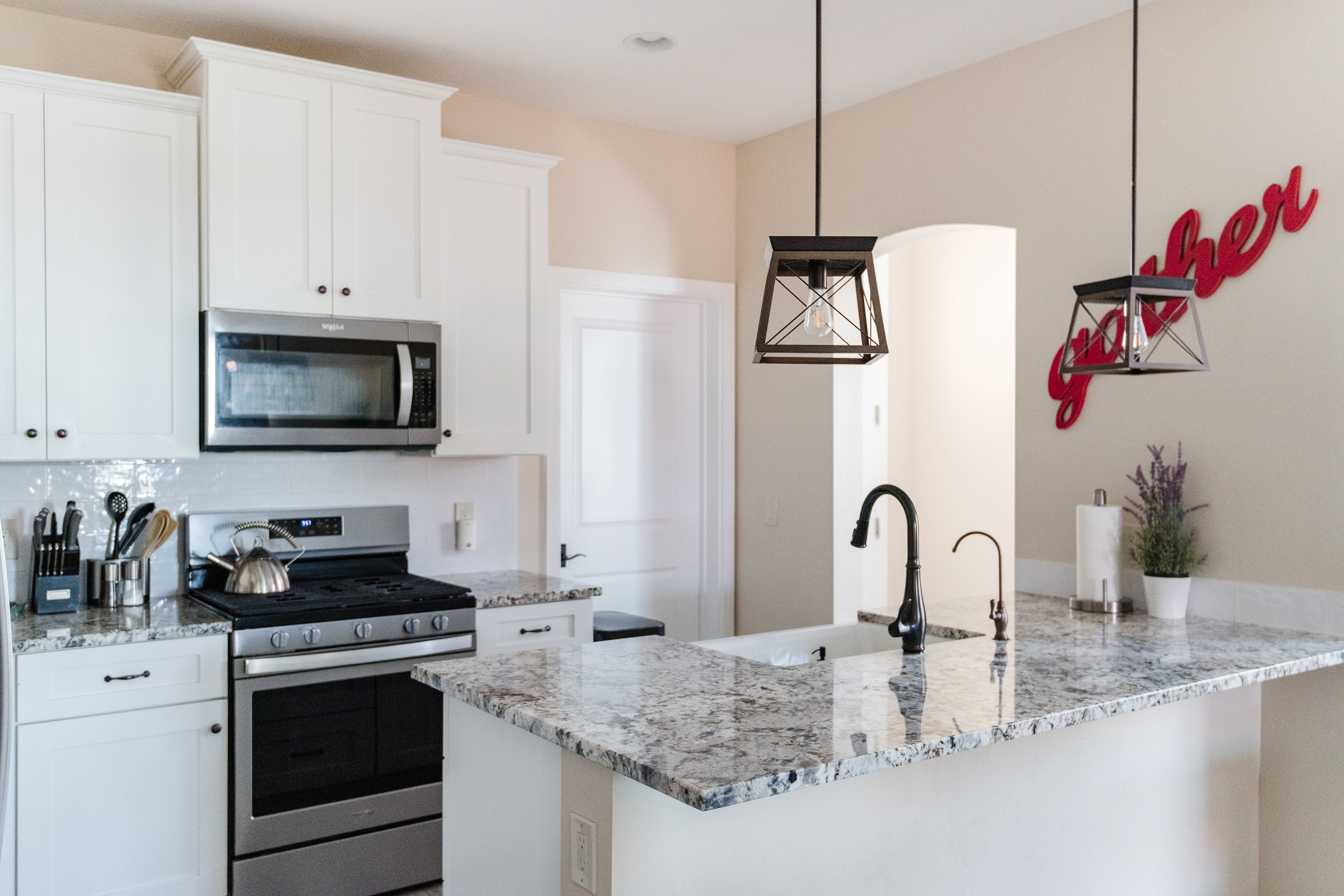 Bright modern kitchen with granite counters and stylish pendant lighting