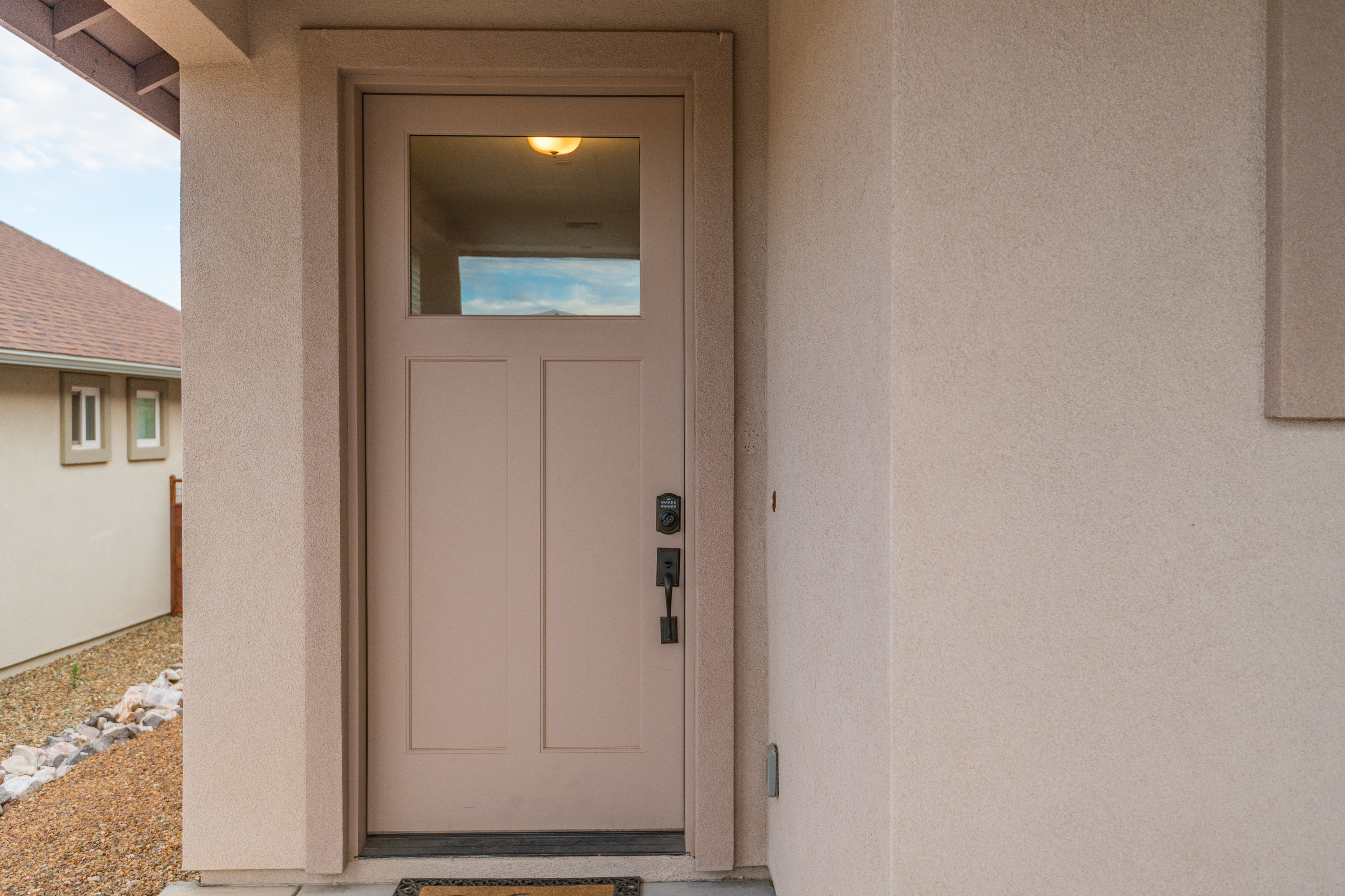 Welcoming covered front entry with modern door and private feel
