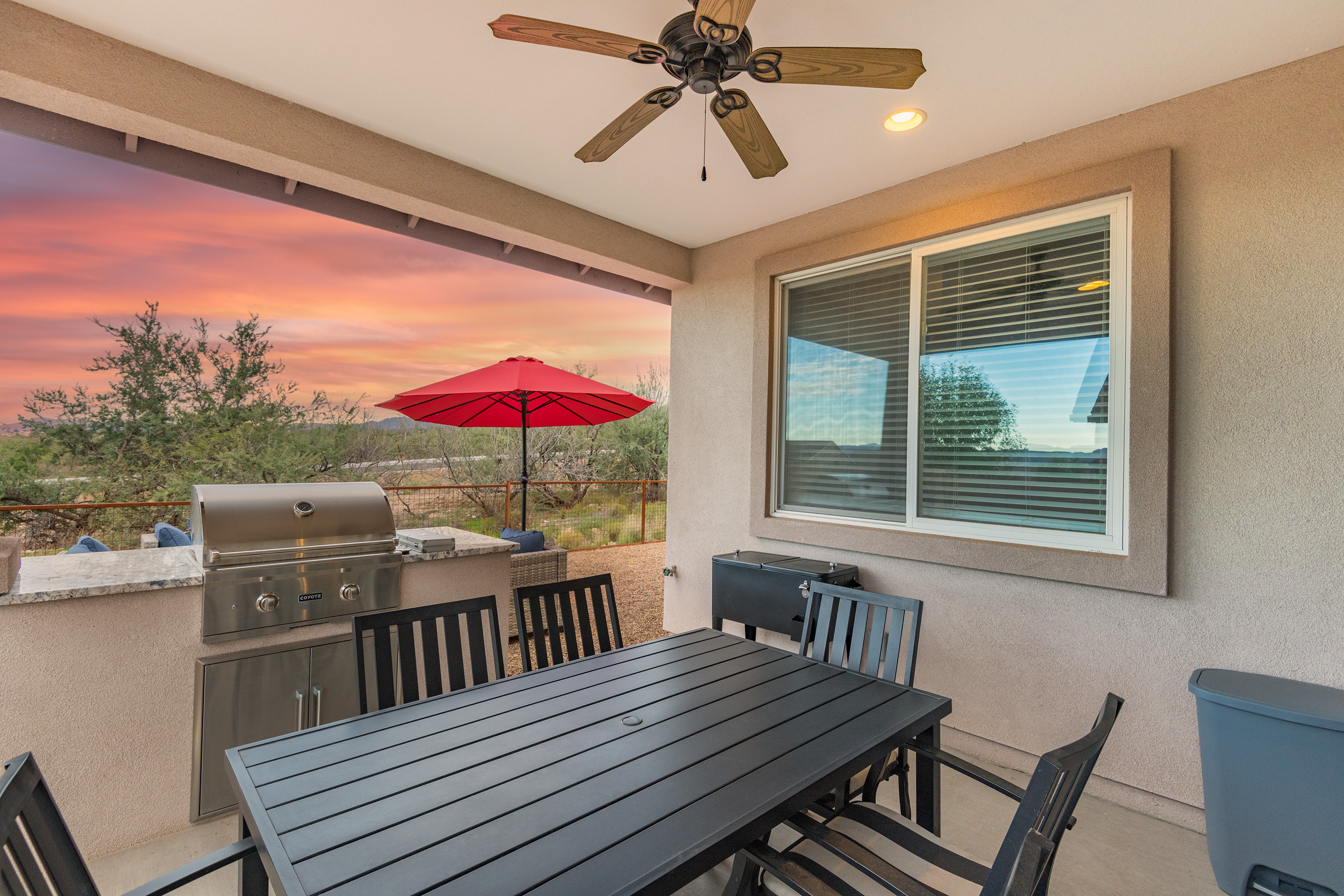 Covered patio with grill, dining table, and stunning sunset desert views