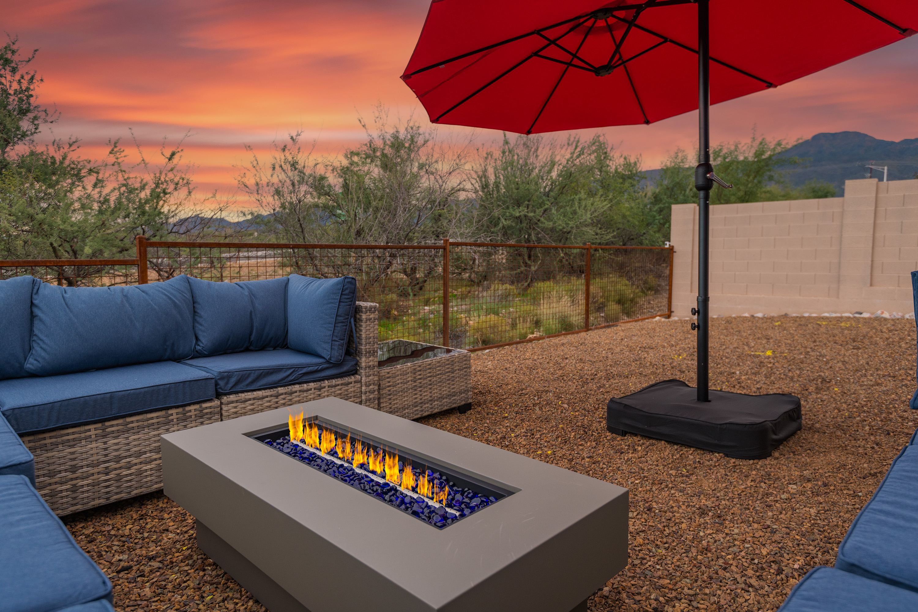 Sunset desert patio with fire table, lounge seating, and mountain views