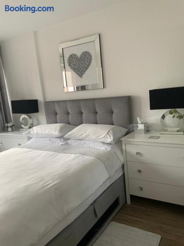 Bright modern bedroom with plush bed, elegant decor, and crisp linens