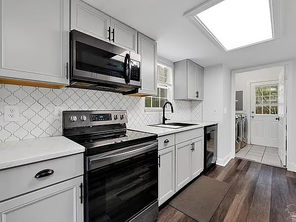 Bright modern kitchen with skylight, stylish finishes, and laundry access