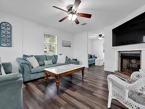 Bright, spacious living room with fireplace, big TV, and cozy seating
