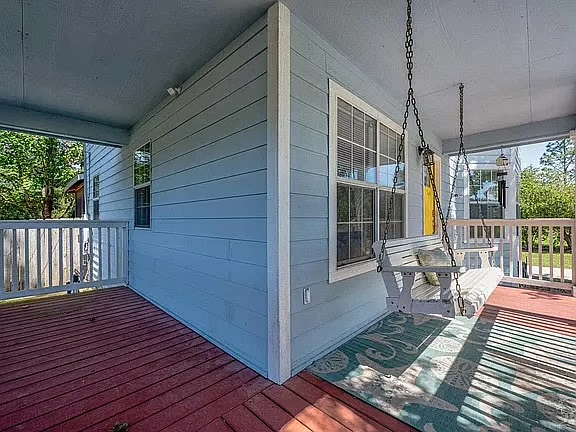 Charming covered porch with swing and roomy deck for relaxing outdoors