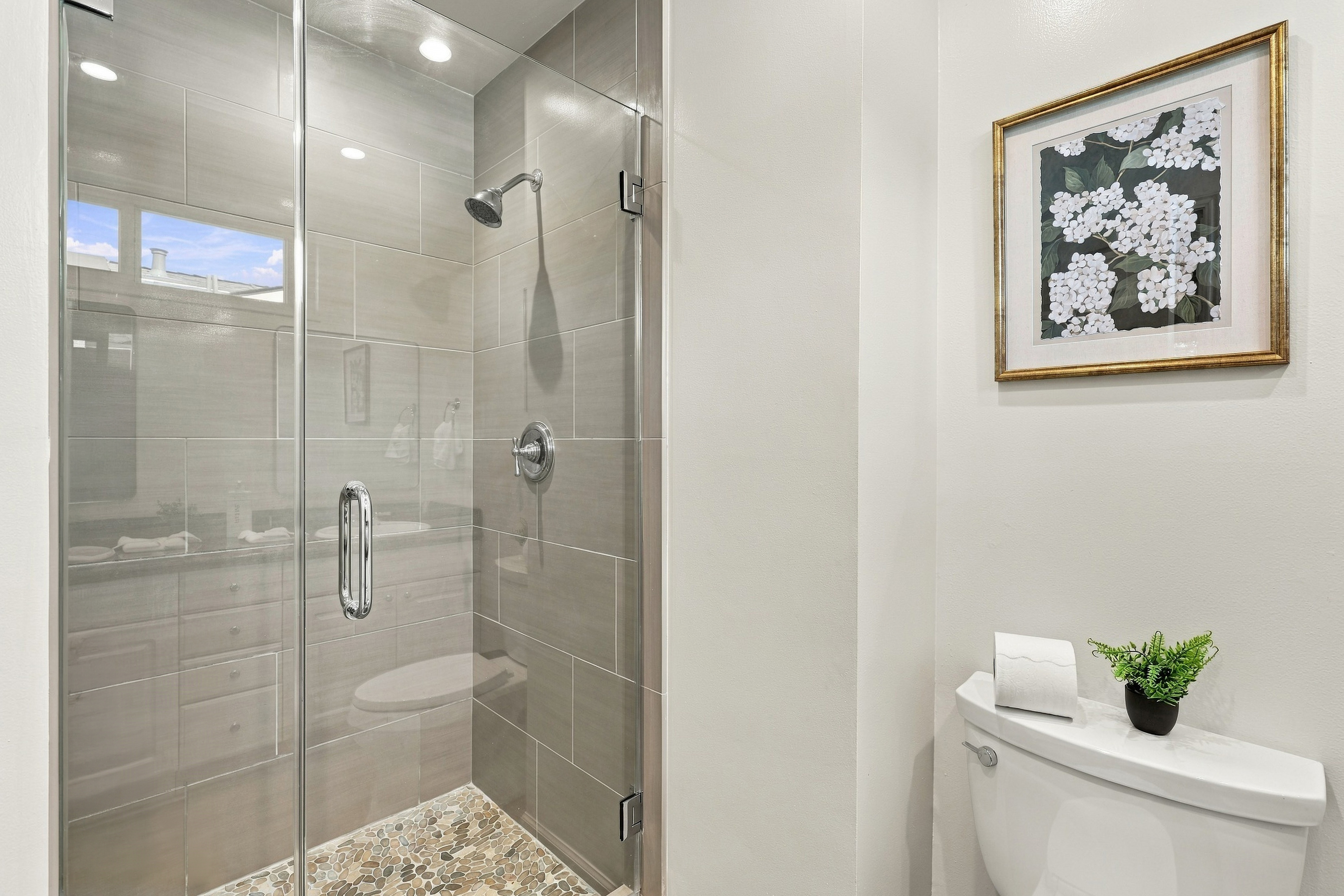 Modern bath with glass walk-in shower and spa-inspired pebble tile floor