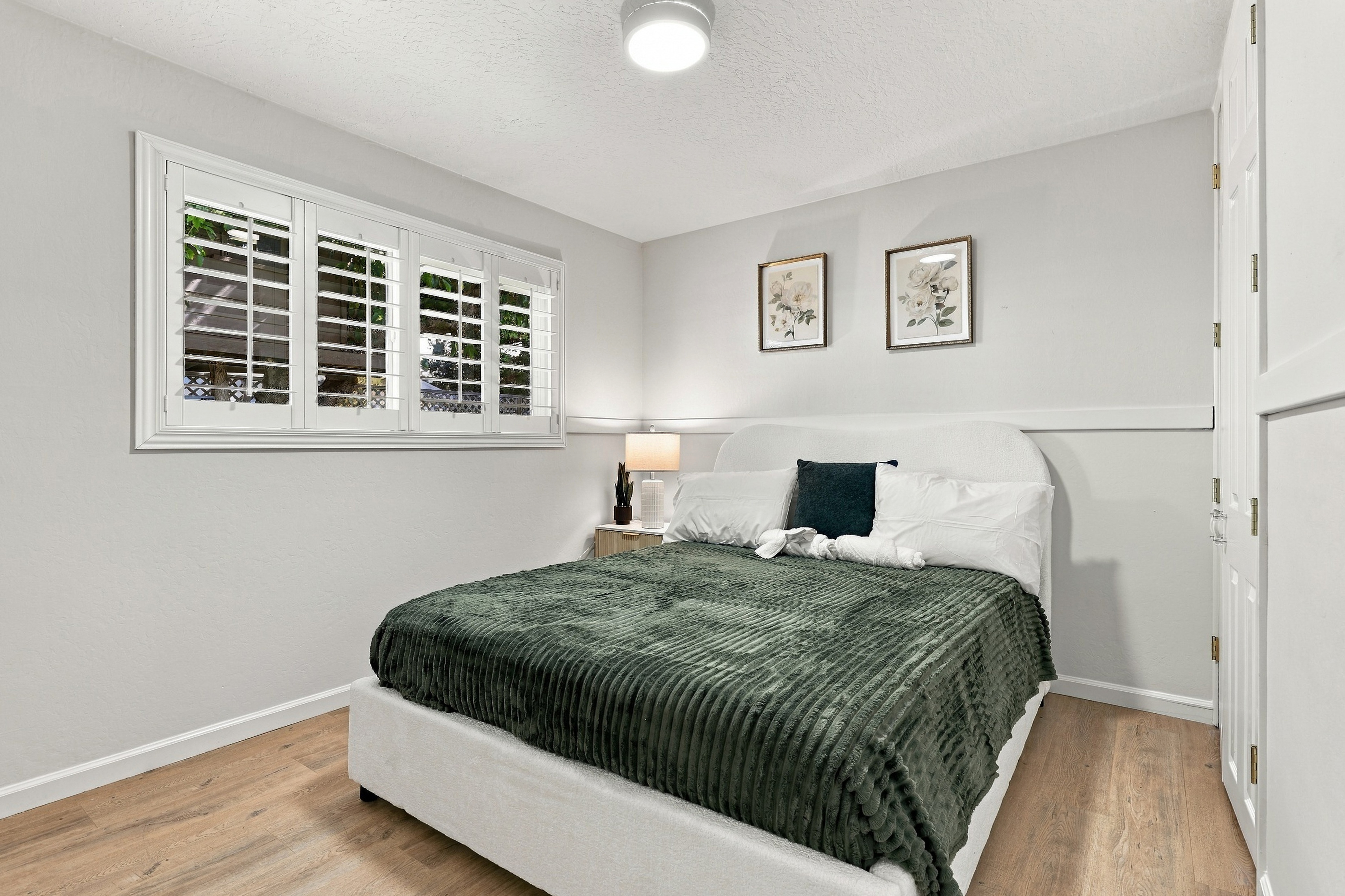 Bright, cozy bedroom with plantation shutters and stylish decor