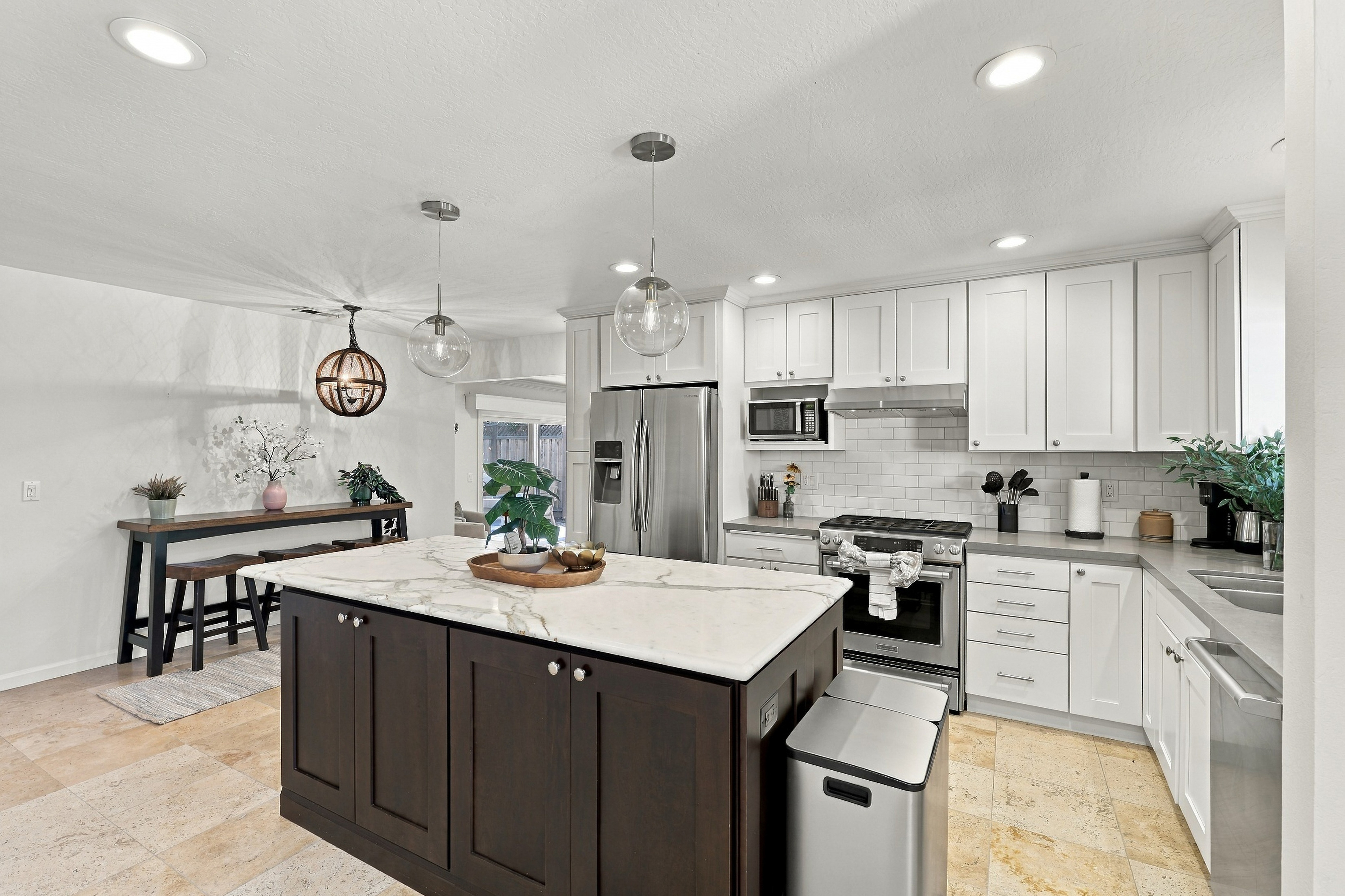 Bright modern kitchen with large island, stainless appliances, and dining nook