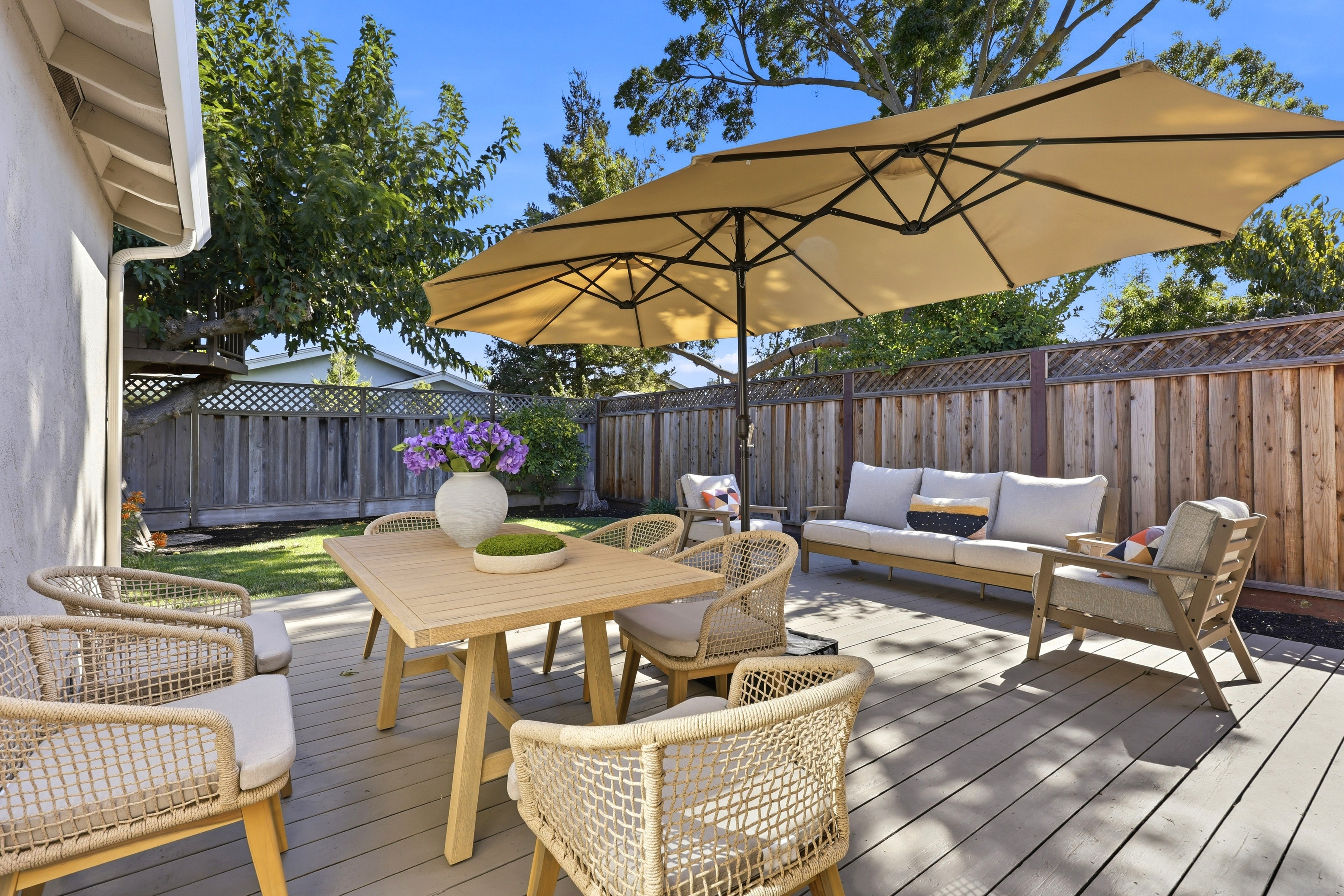 Private sunny patio with shaded lounge seating and outdoor dining
