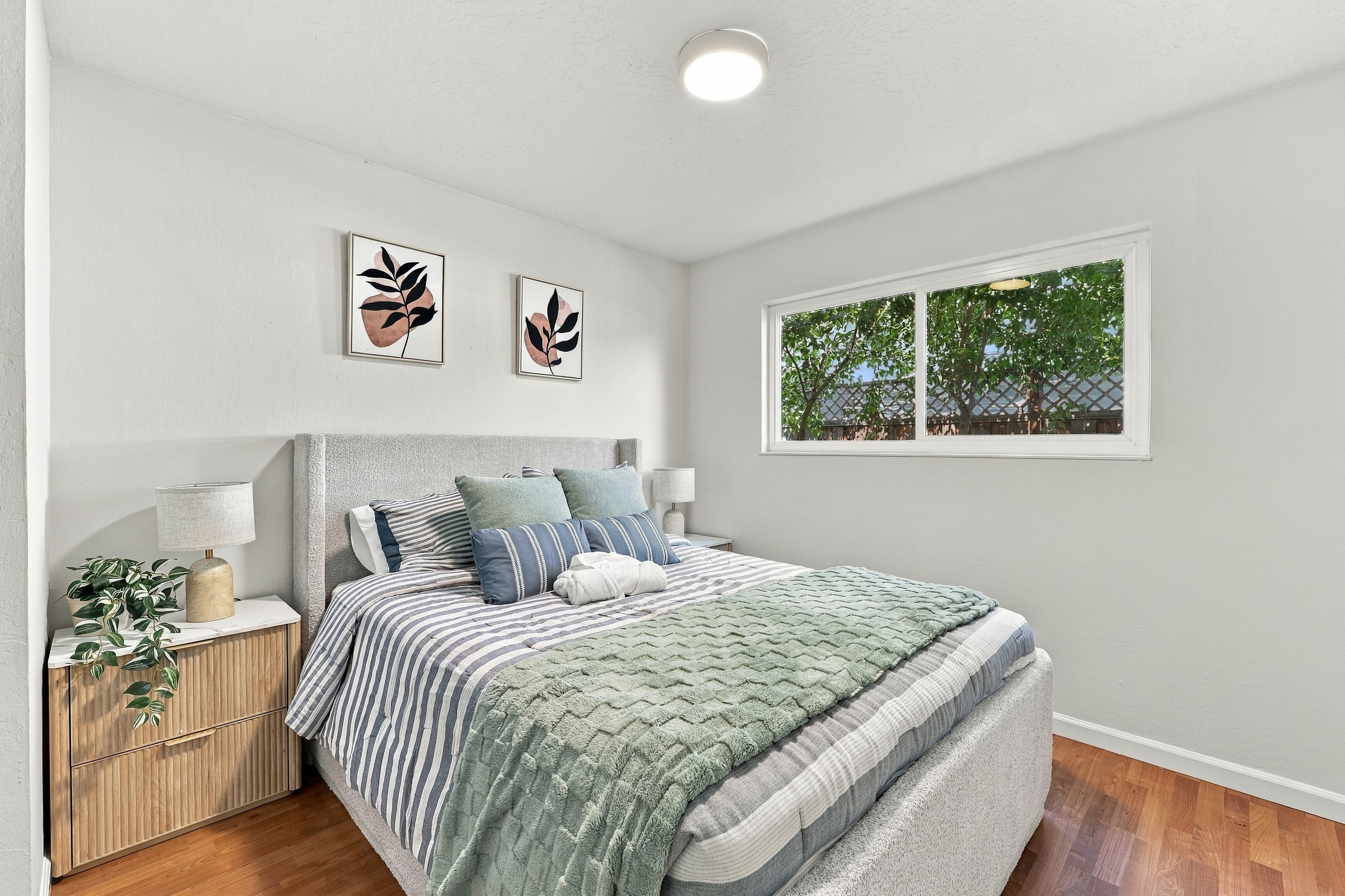 Bright, cozy bedroom with natural light and serene greenery views