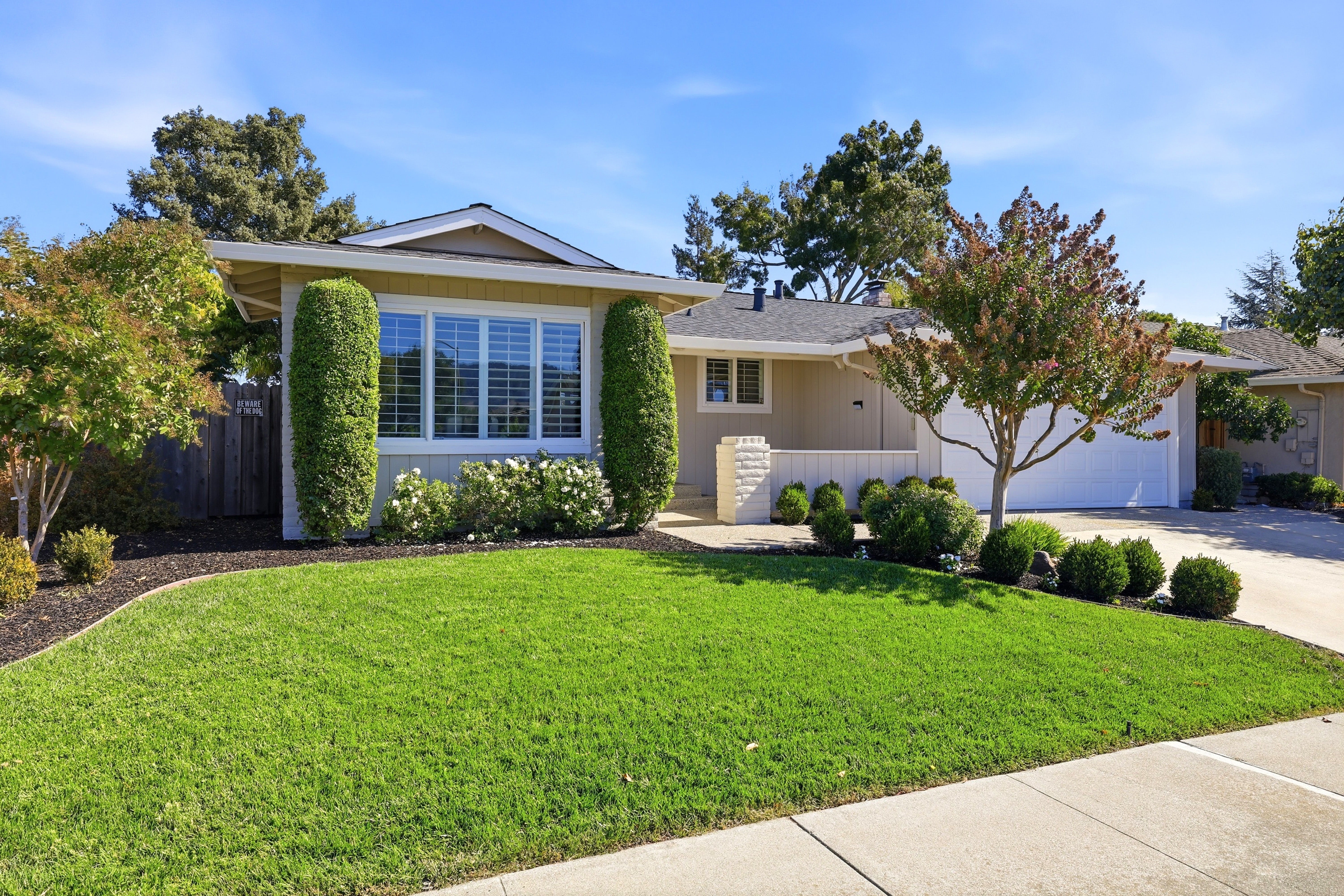 Charming home with lush lawn, manicured landscaping, and inviting curb appeal