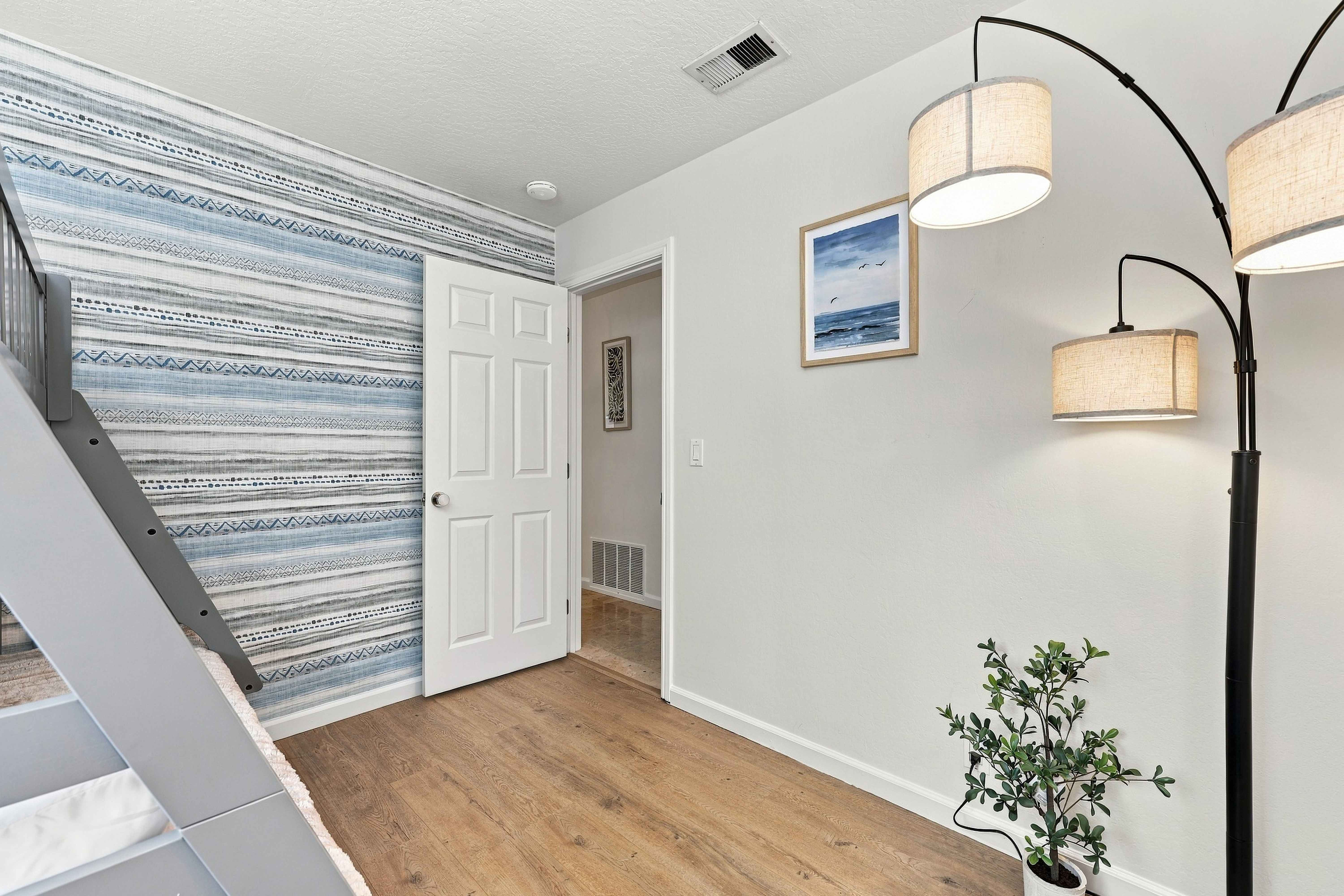 Bright coastal-inspired interior with stylish lighting and accent wall