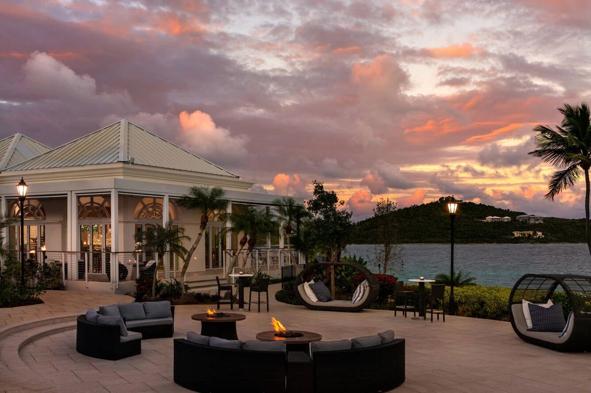 Waterfront sunset patio with fire pits, lounge seating, and resort-style vibes