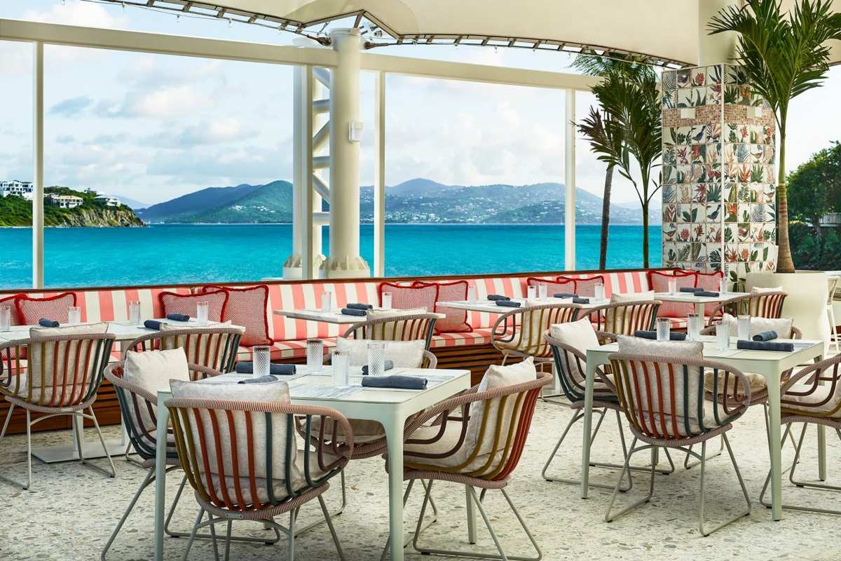 Chic waterfront terrace dining with sweeping turquoise bay views