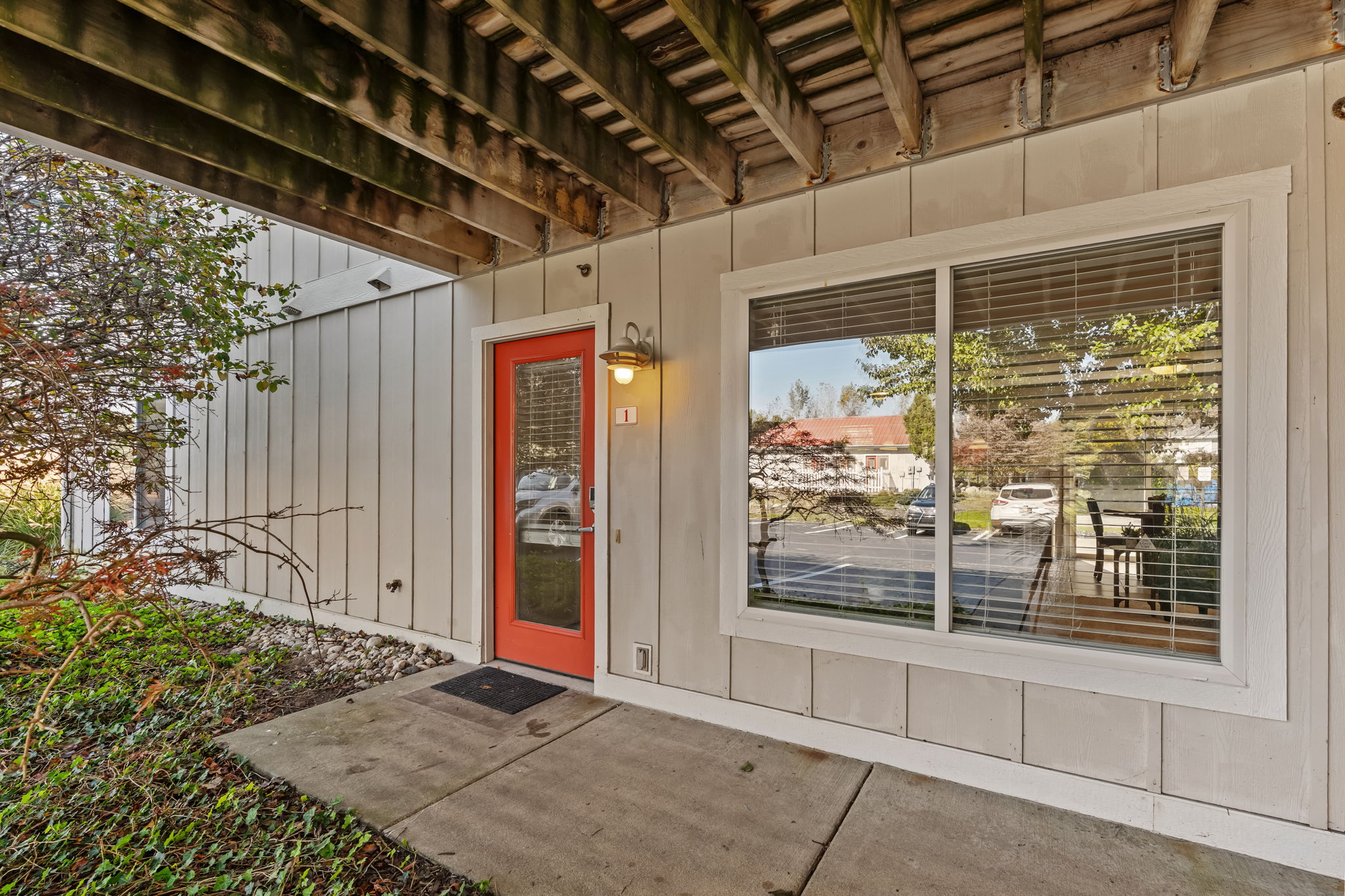 Welcoming covered entry with a bright red door and private patio feel