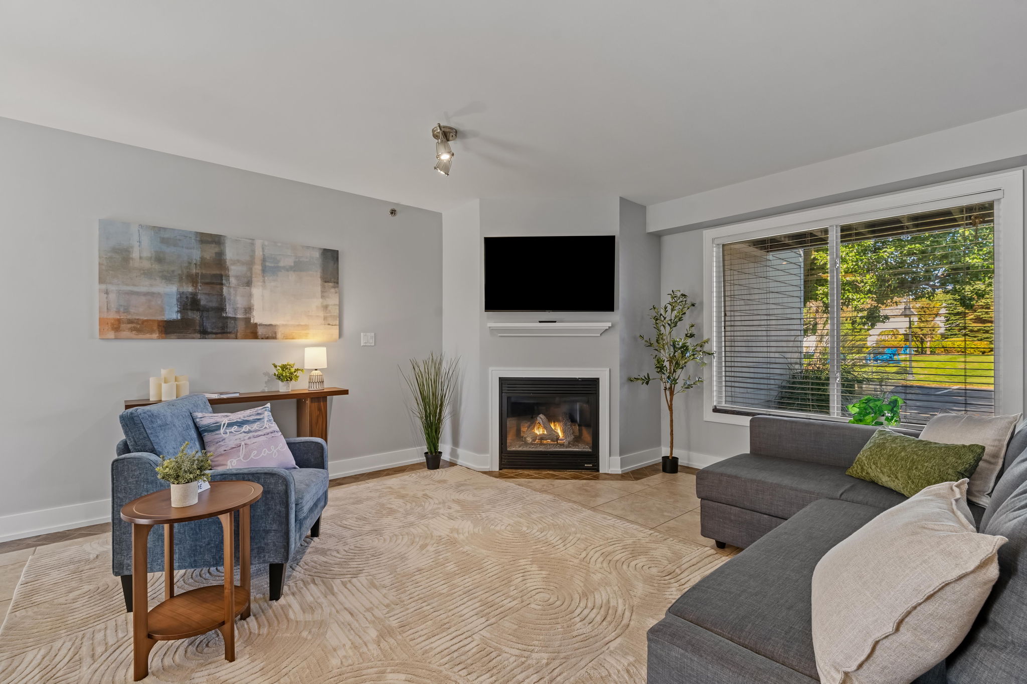 Bright living room with fireplace, large windows, and comfy seating