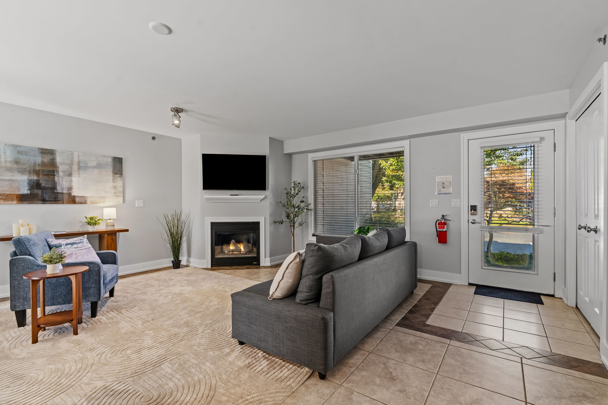 Bright living room with fireplace, TV, and plenty of natural light