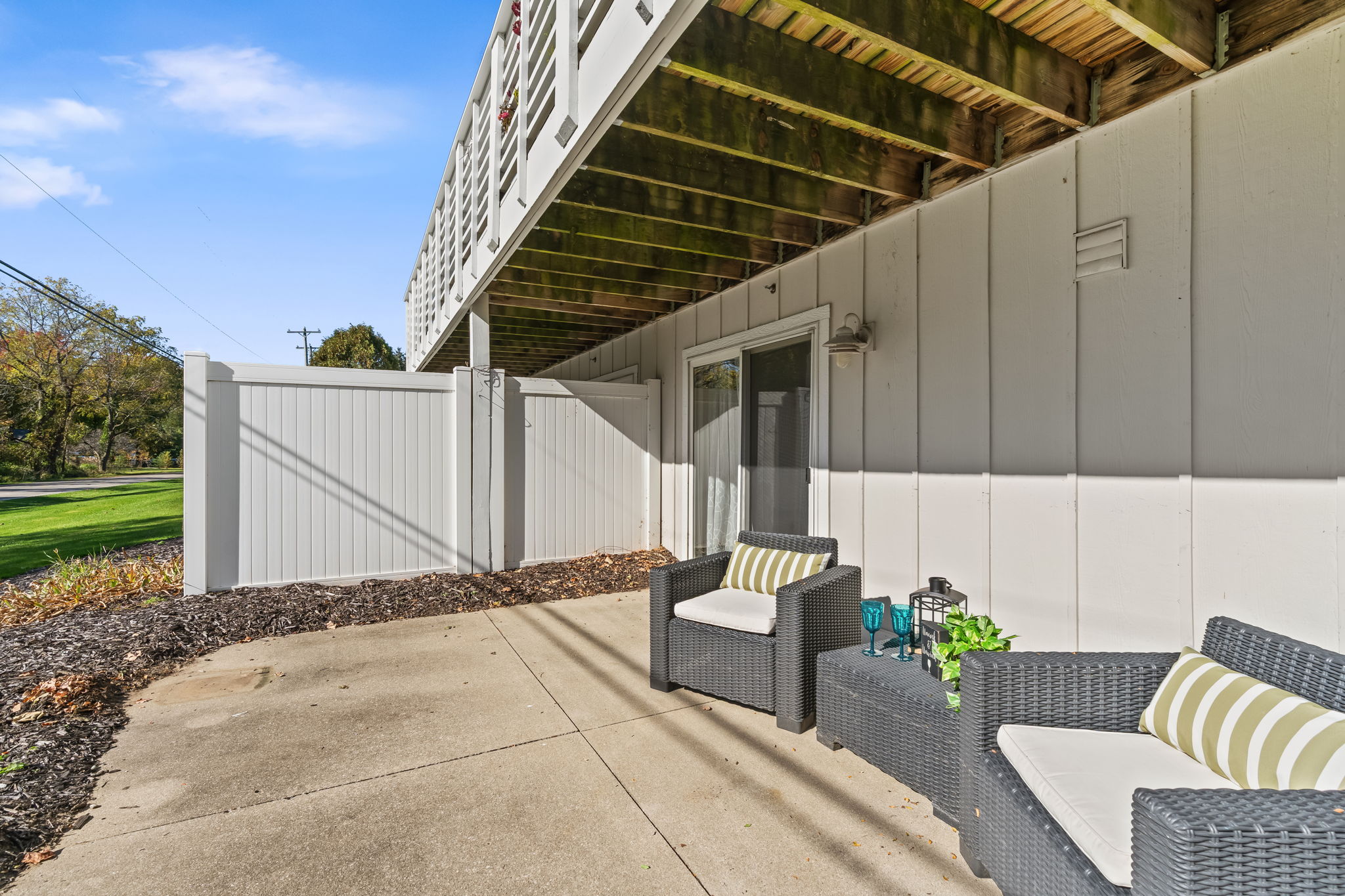 Private shaded patio with cozy seating and fenced-in outdoor space