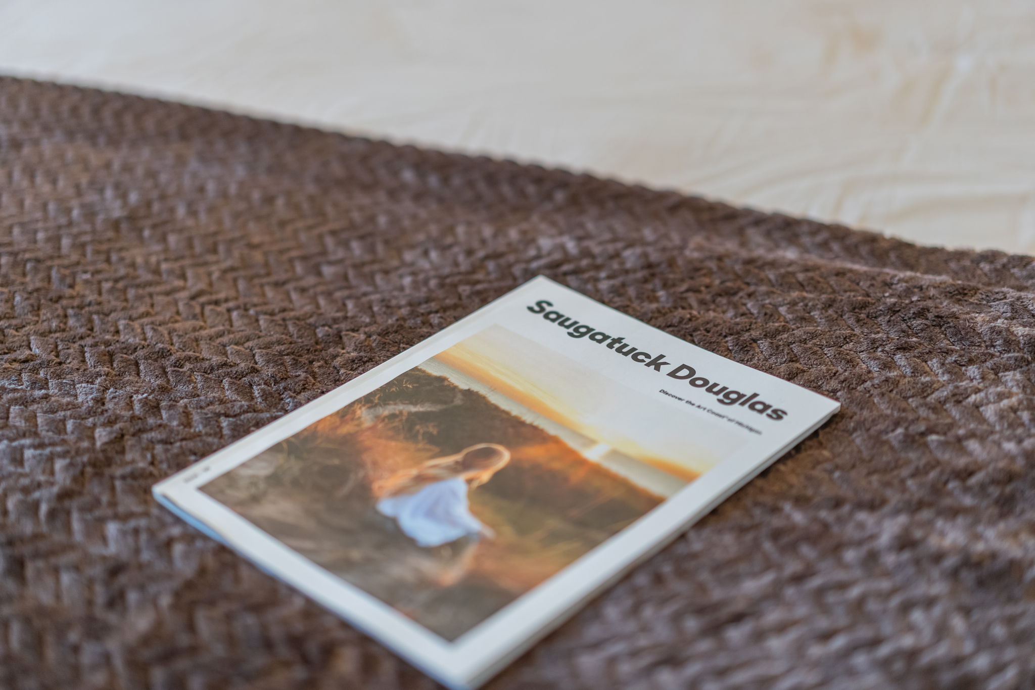 Guest-ready bed with local guidebook for exploring Saugatuck Douglas