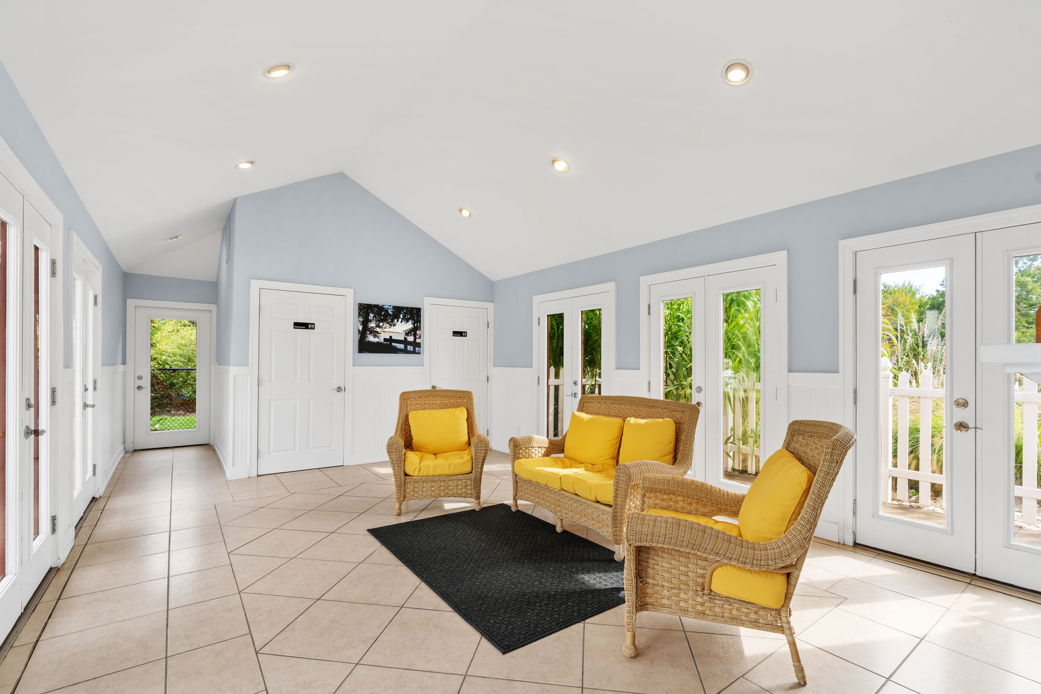 Bright sunroom lounge with garden views and cheerful wicker seating