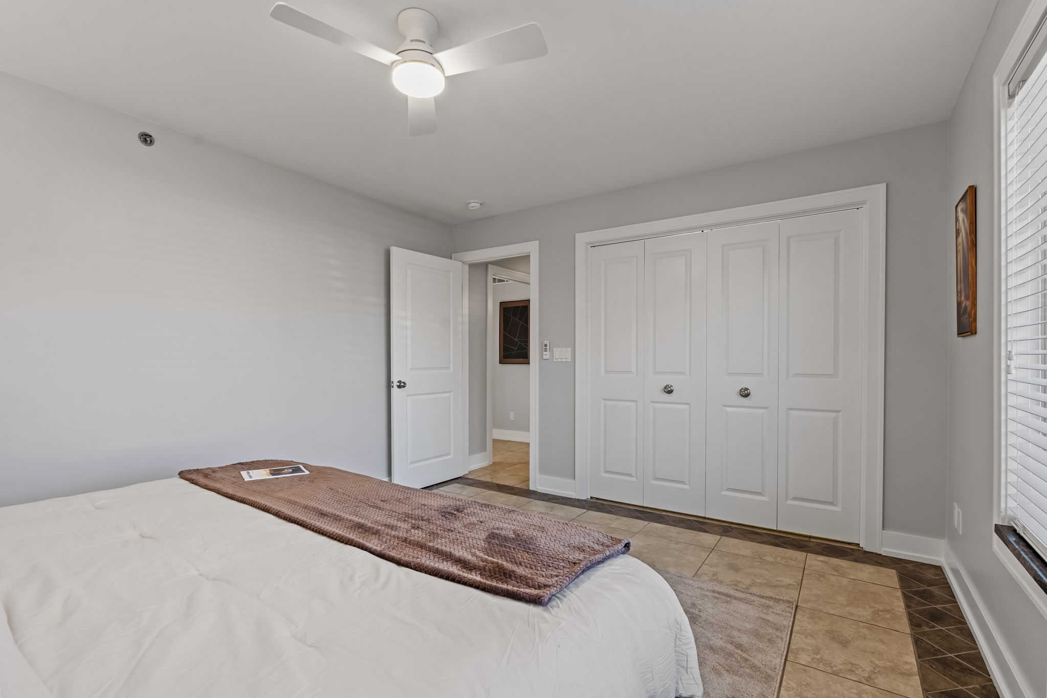 Bright, modern bedroom with ceiling fan and spacious closet