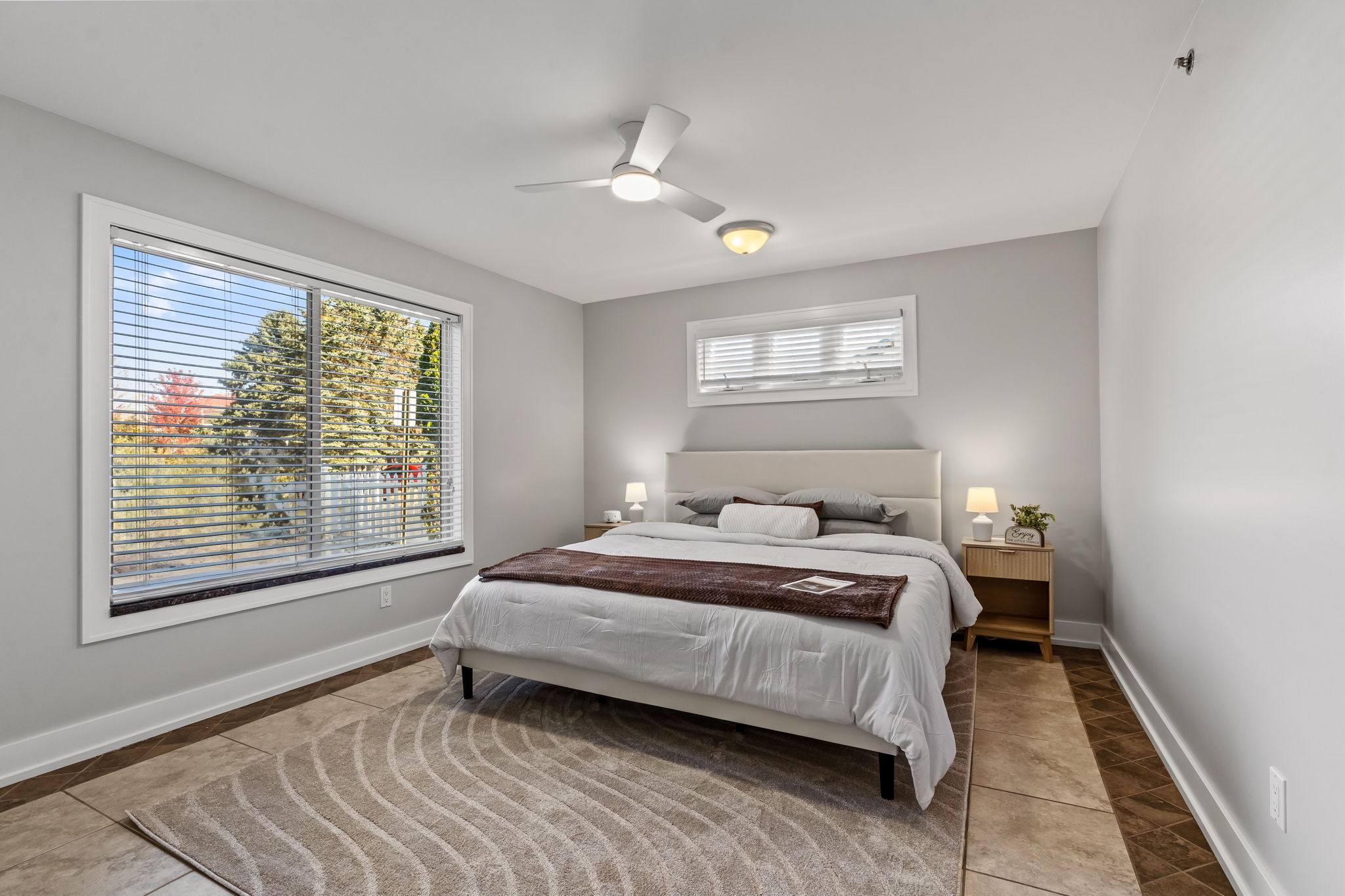 Bright, airy bedroom with large windows and a cozy modern design