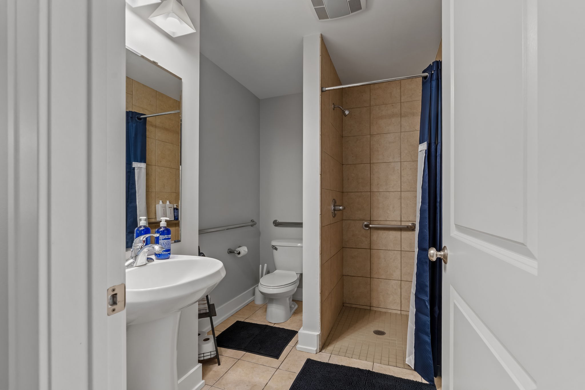 Bright bathroom with walk-in tiled shower and accessible features