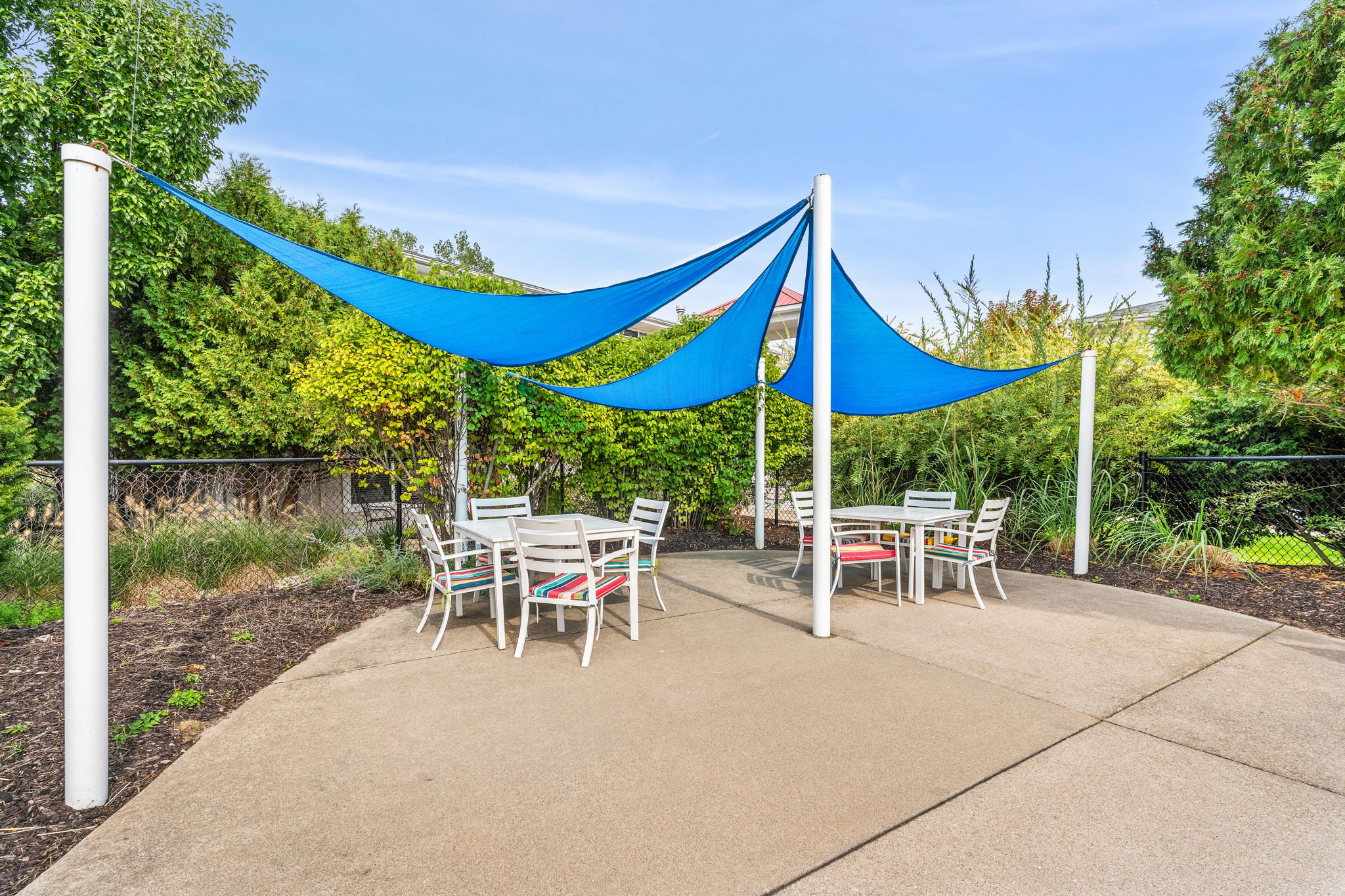 Shaded outdoor patio with garden views and cozy dining seating