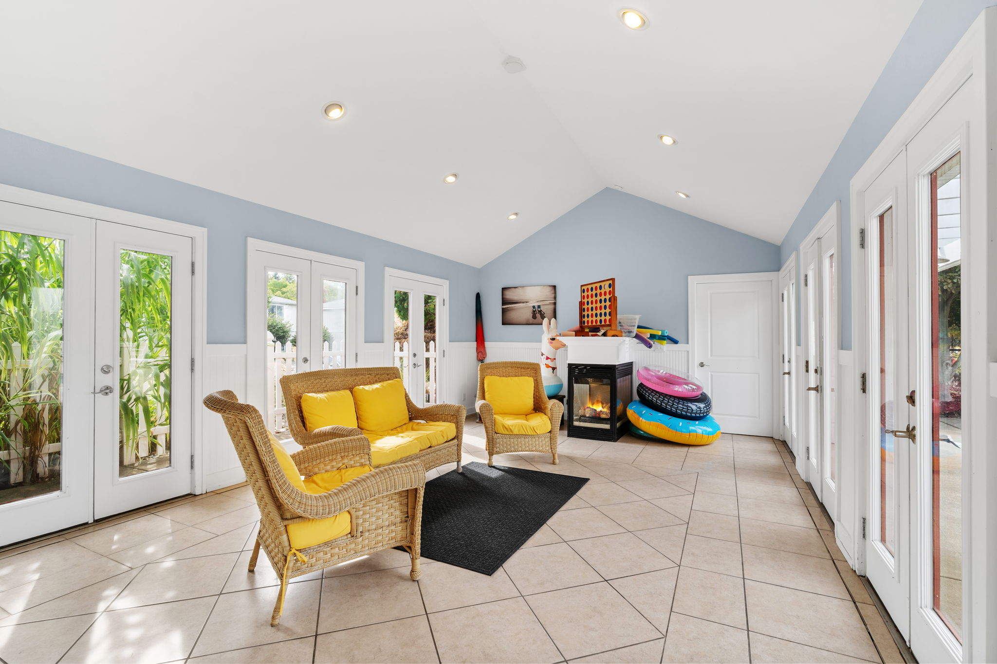 Sunny indoor-outdoor lounge with French doors and cheerful seating