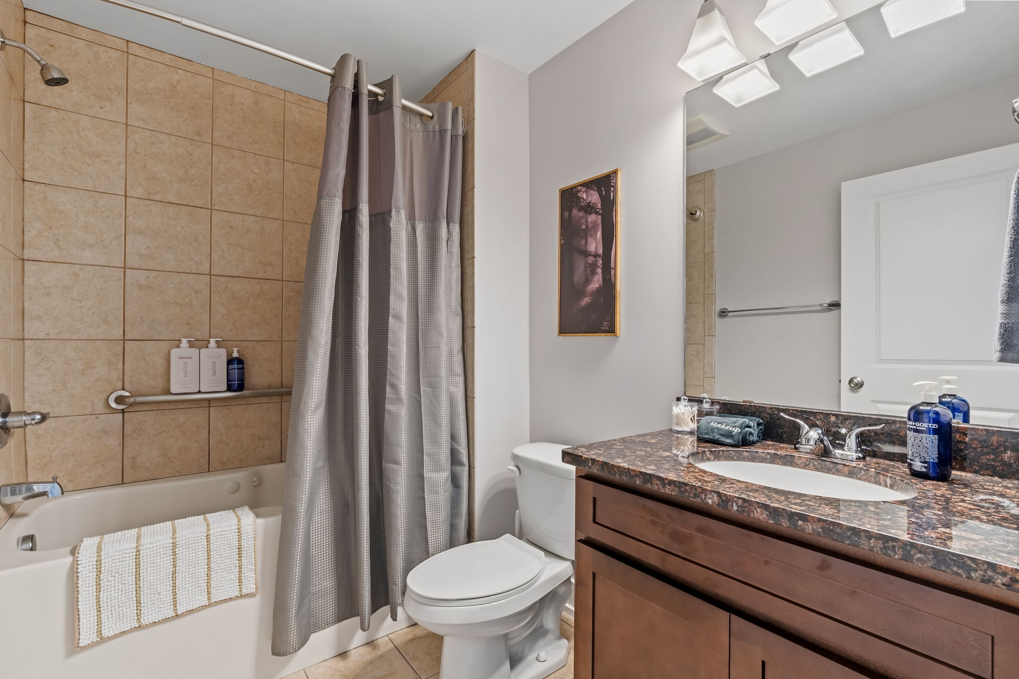 Bright full bath with granite vanity and tiled shower-tub combo