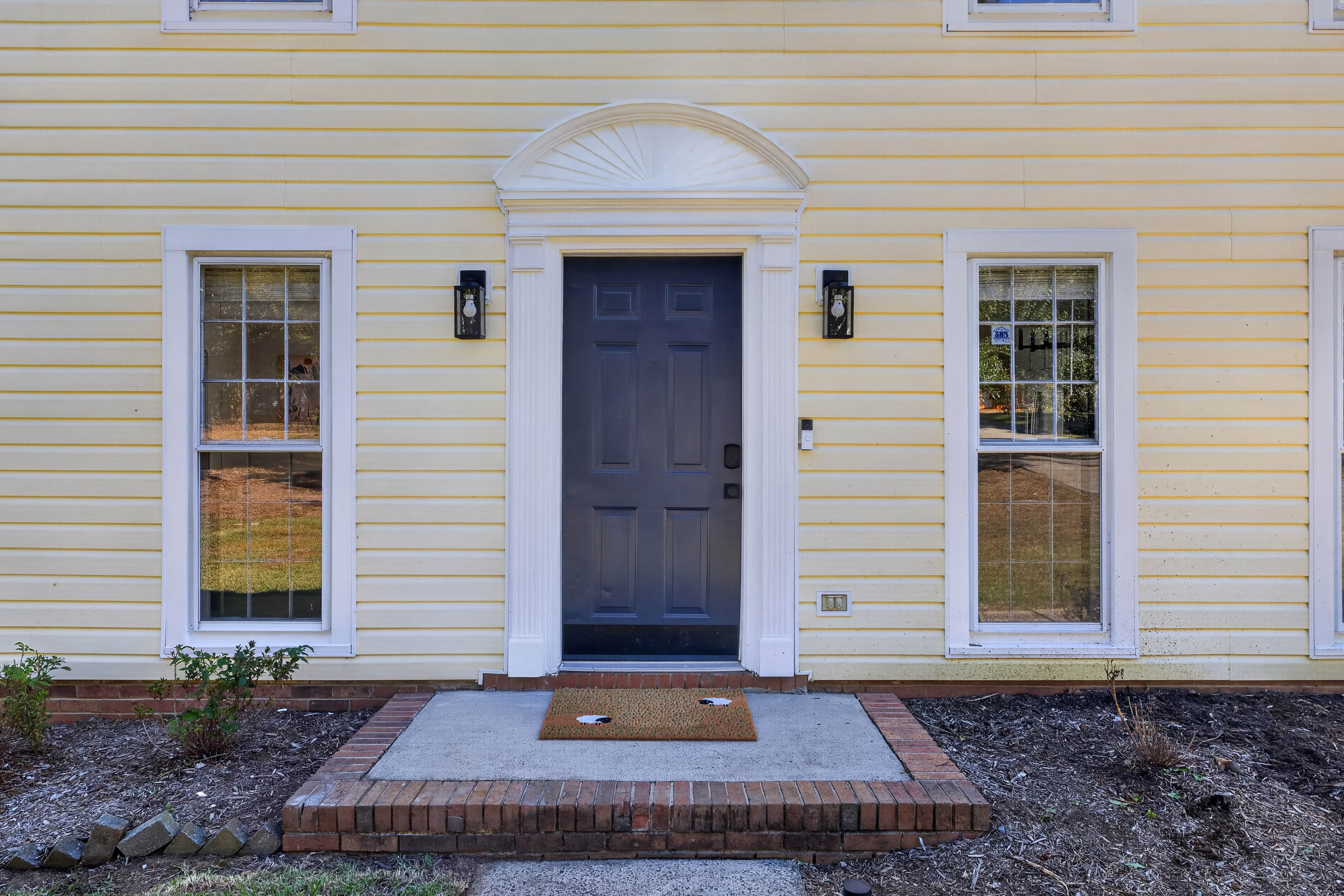 Front door with a brick stoop