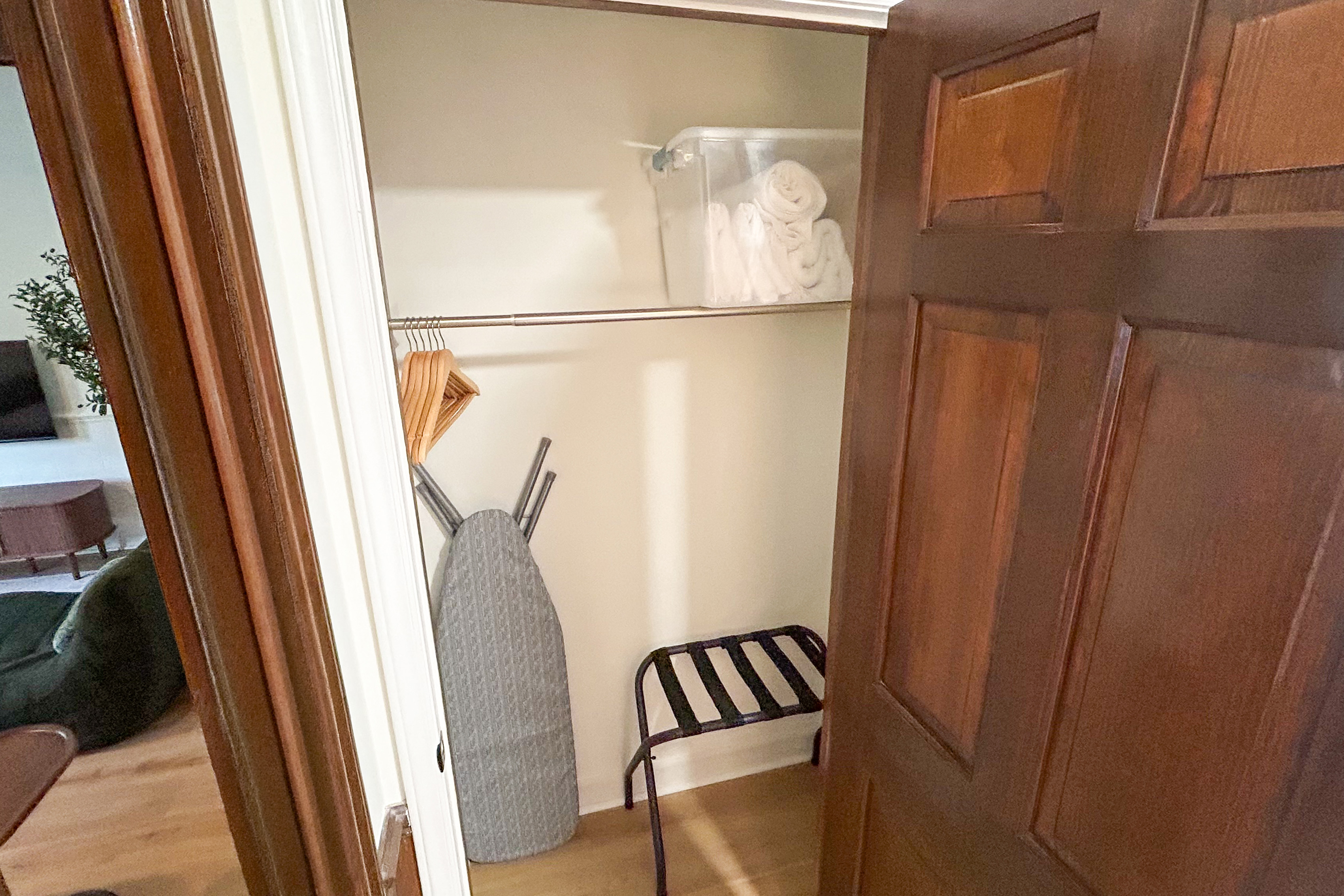 Closet with an ironing board, iron and luggage rack