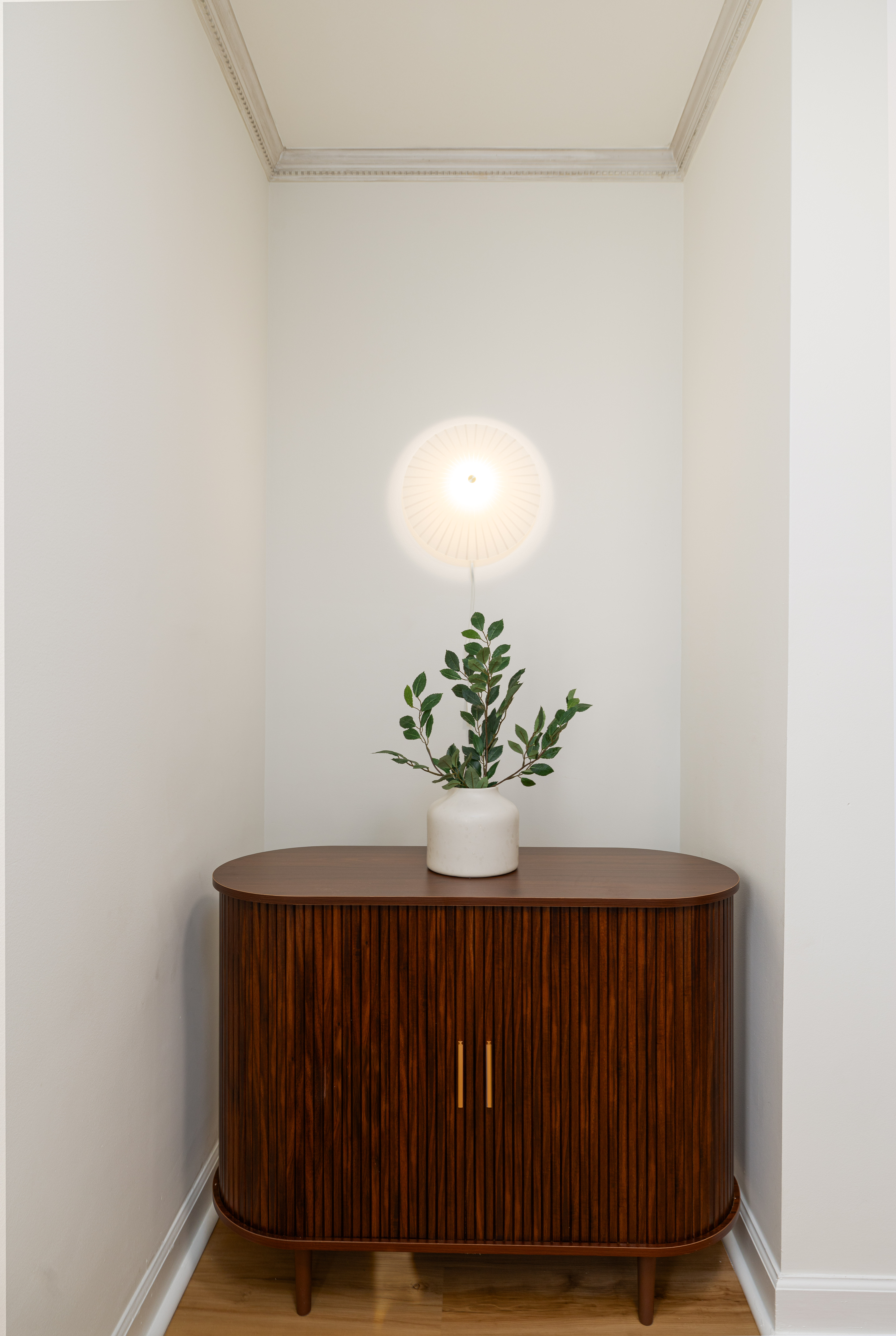 Hallway nook with a walnut cabinet and wall light