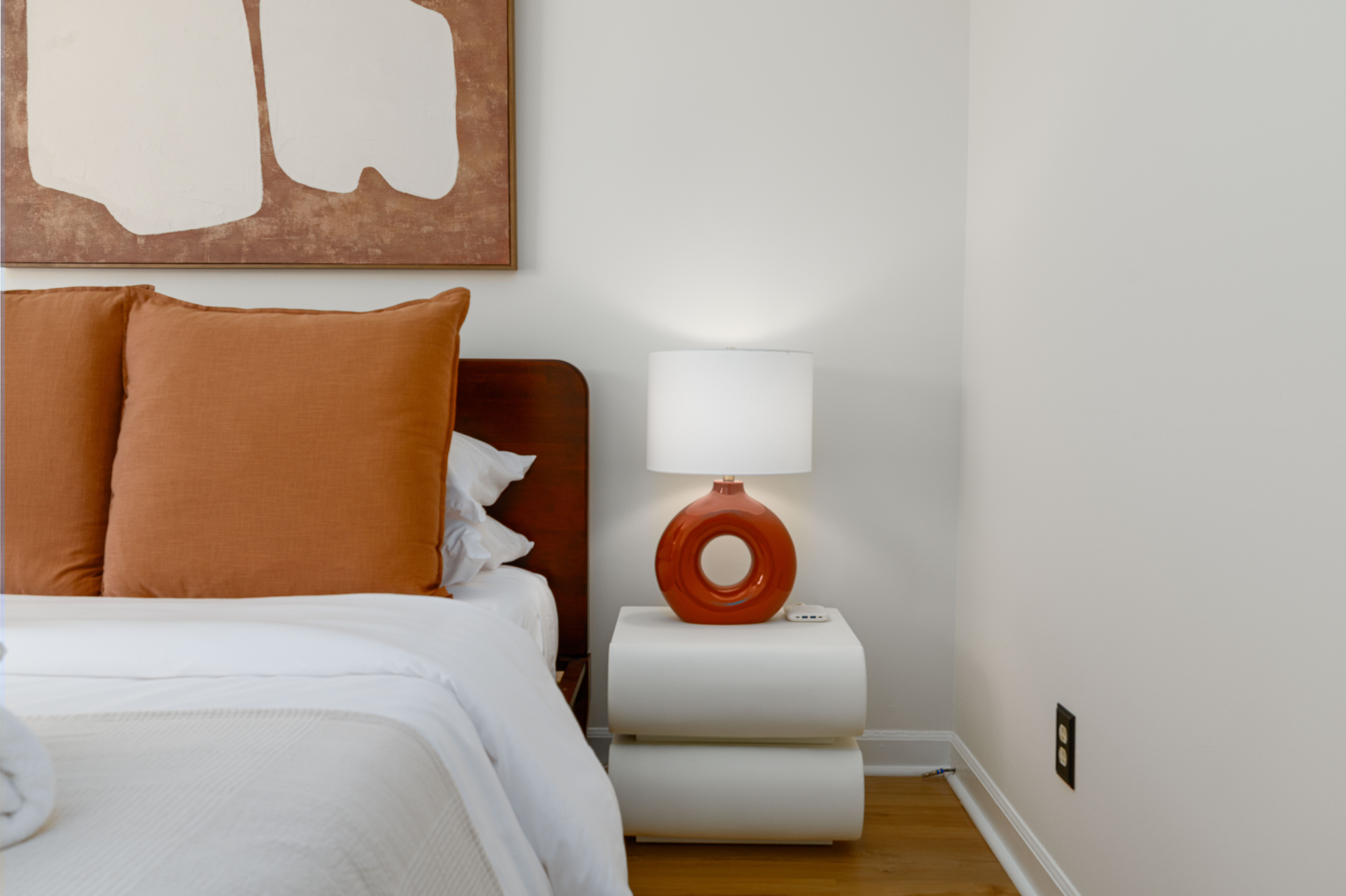 Bedroom 2: queen bed and nightstand under abstract art