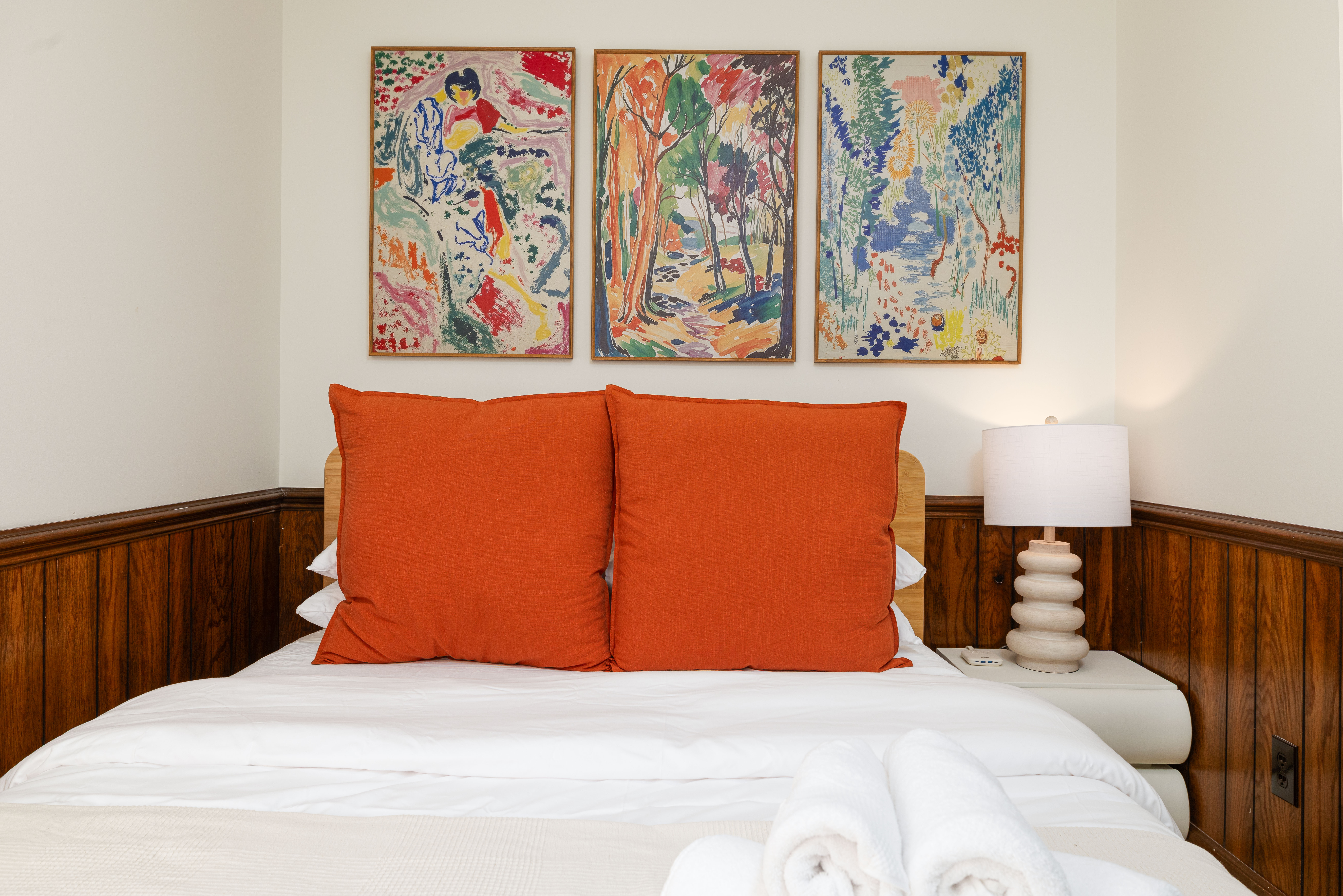 Bedroom 4 (downstairs): queen bed under three framed prints