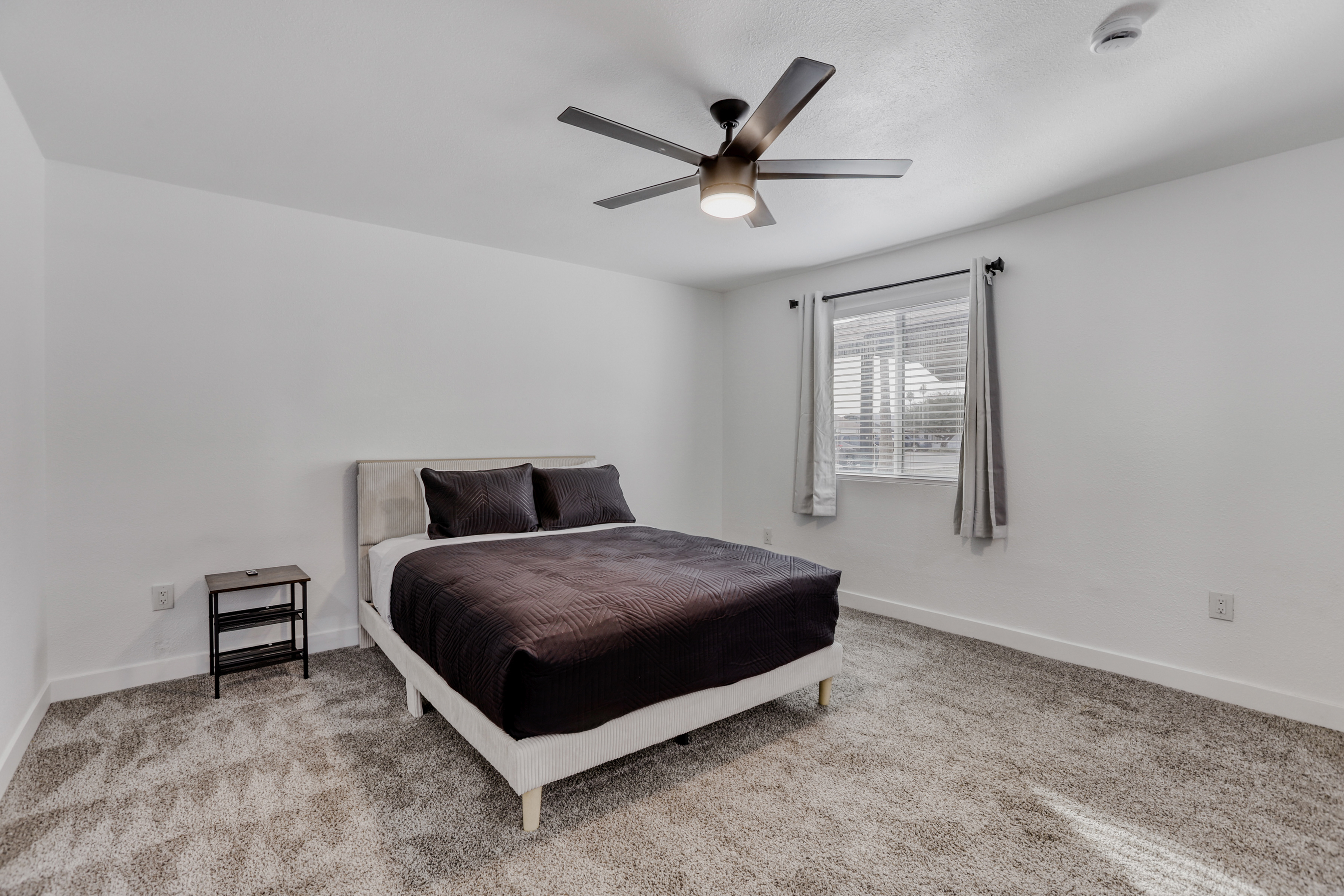 Bright, spacious bedroom with plush carpet and a calming, modern feel