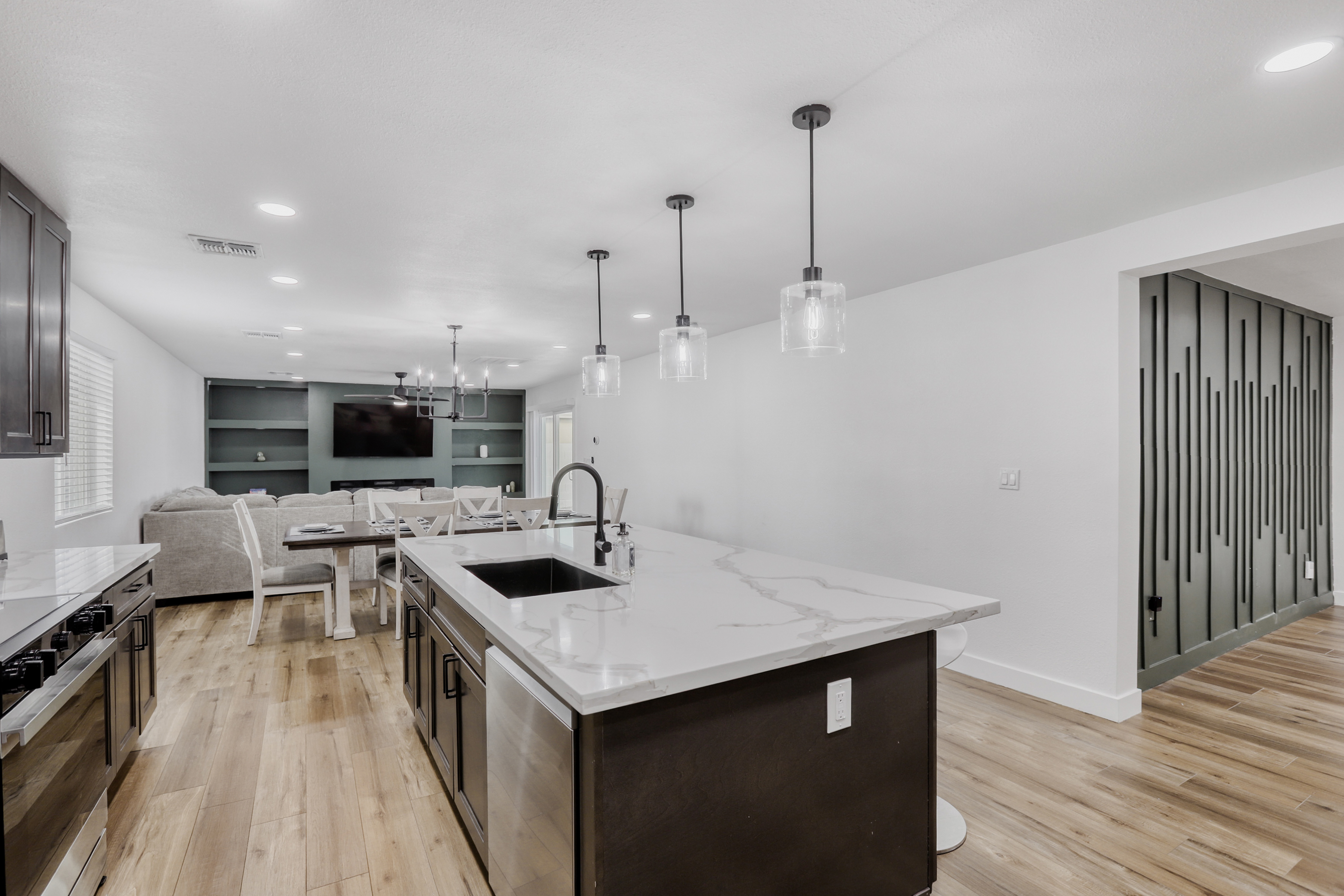 Bright open kitchen with waterfall island, pendant lighting & modern style