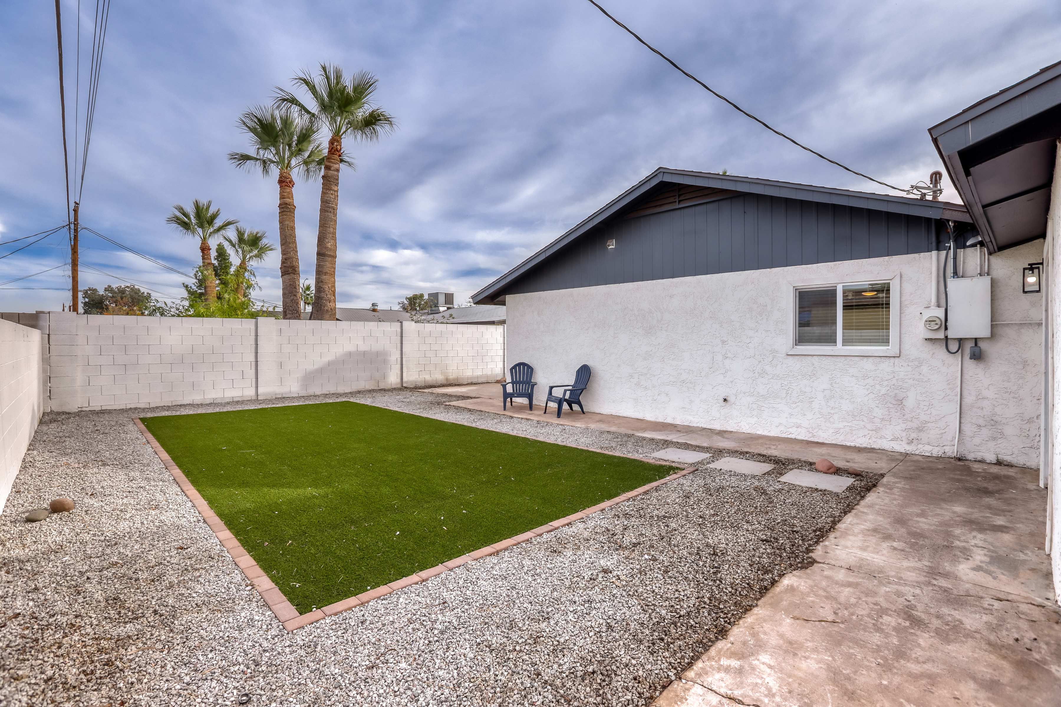 Private fenced backyard with turf lawn and easy outdoor seating