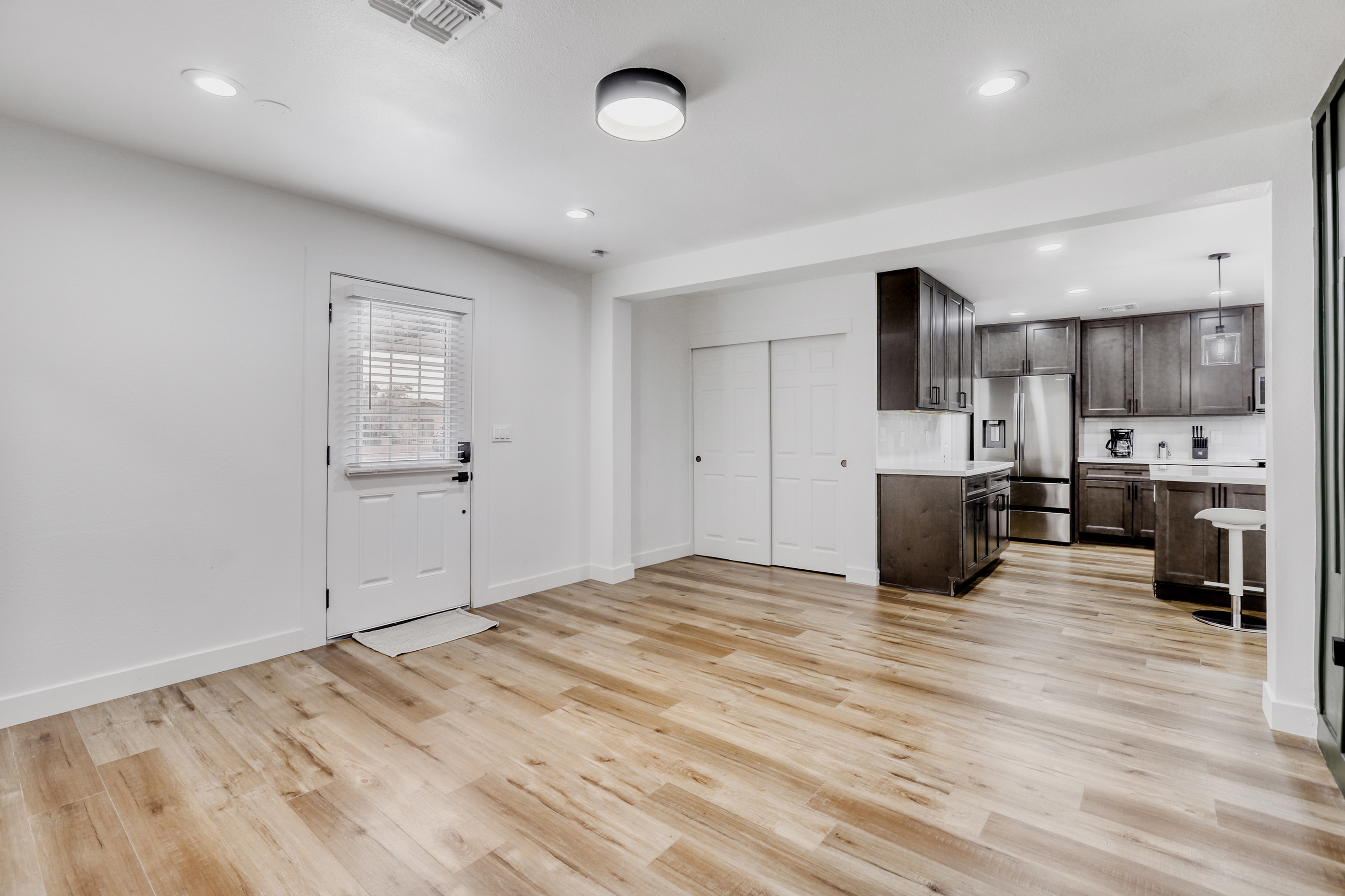 Bright open living space with modern kitchen and warm wood-style floors