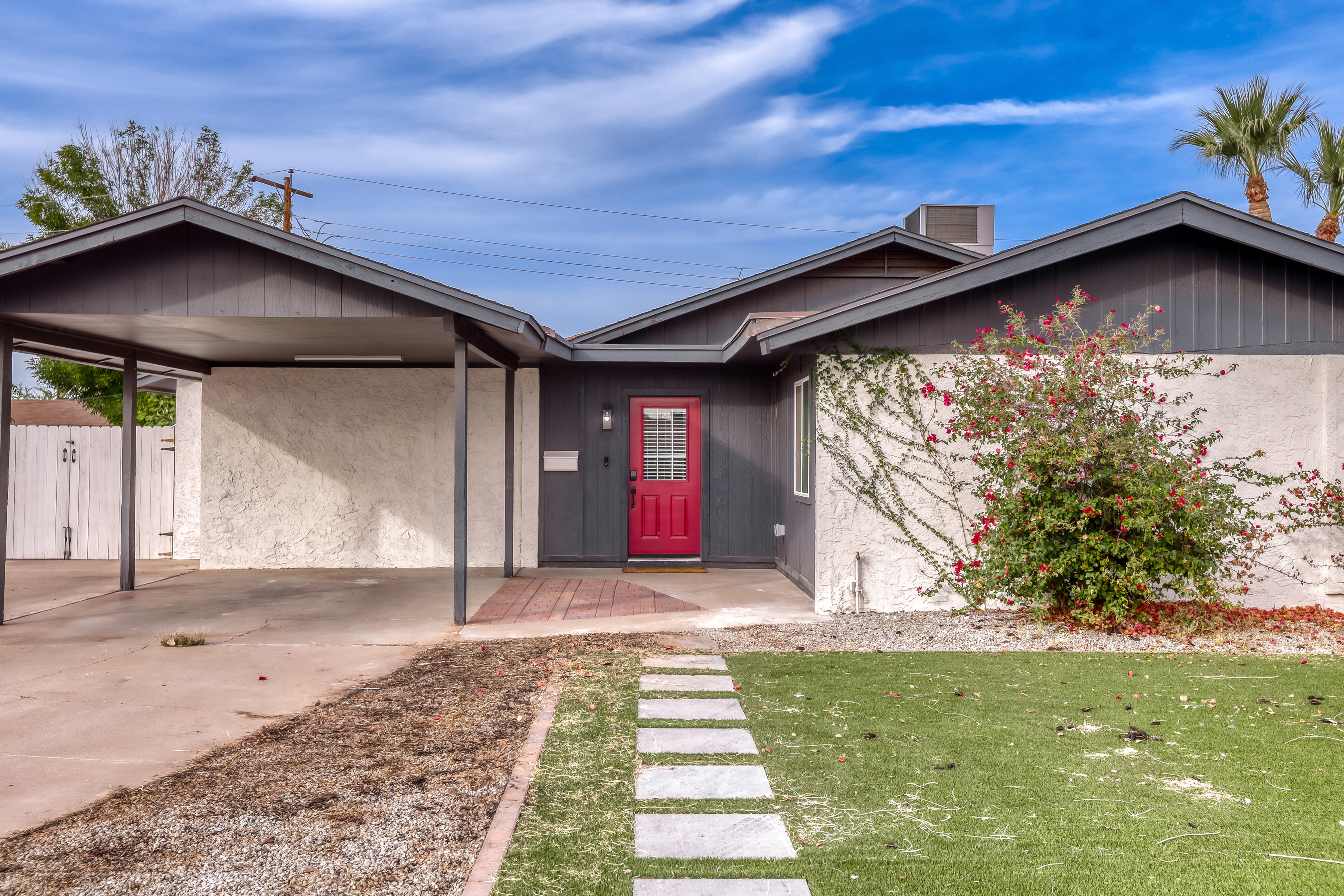 Welcoming curb appeal with covered parking and a bold red entry
