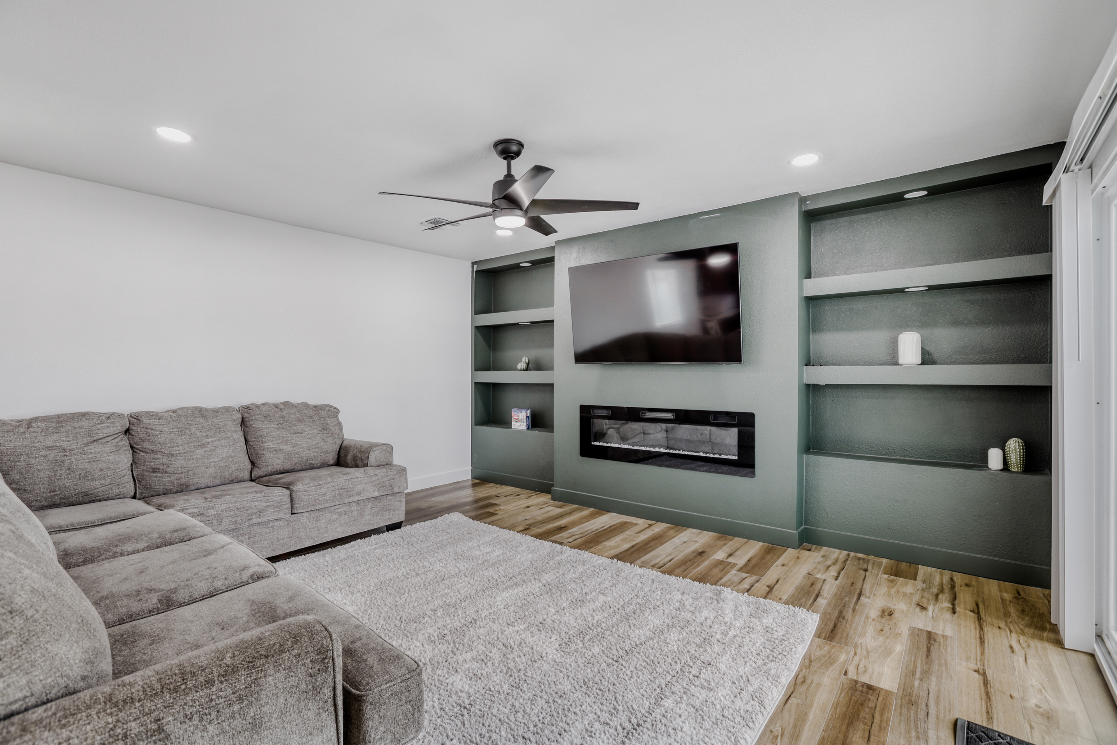 Modern lounge with sectional, fireplace, and large TV for cozy nights in