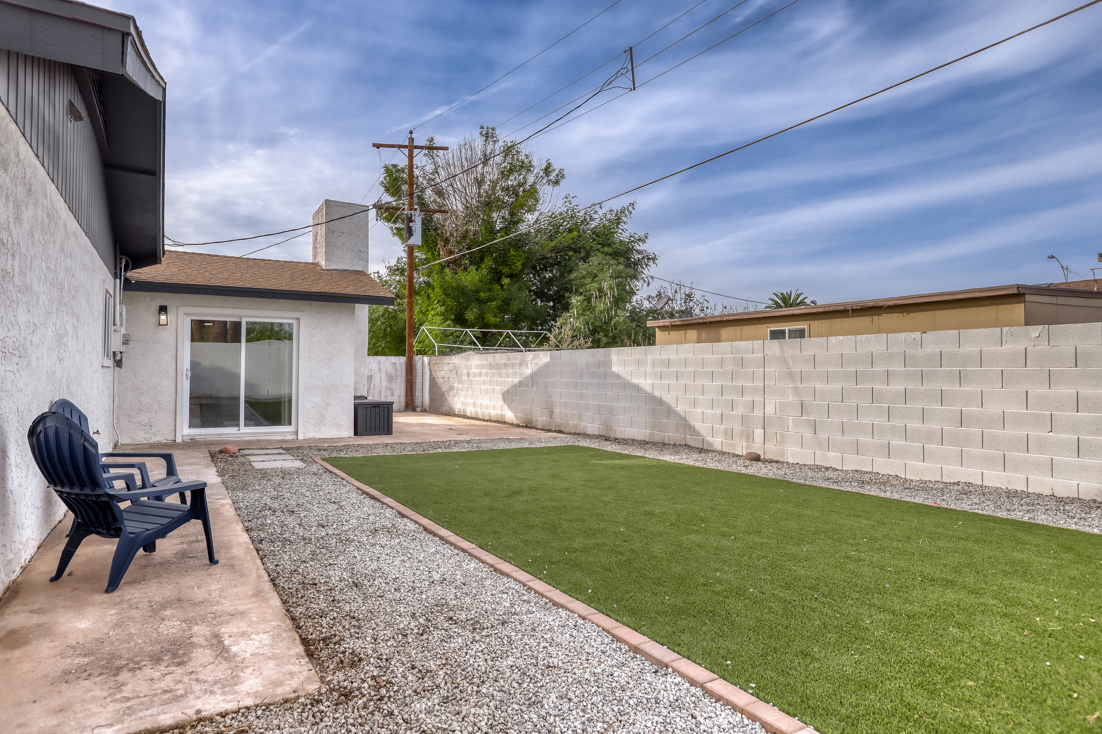 Private backyard with turf lawn, patio seating, and easy indoor-outdoor access