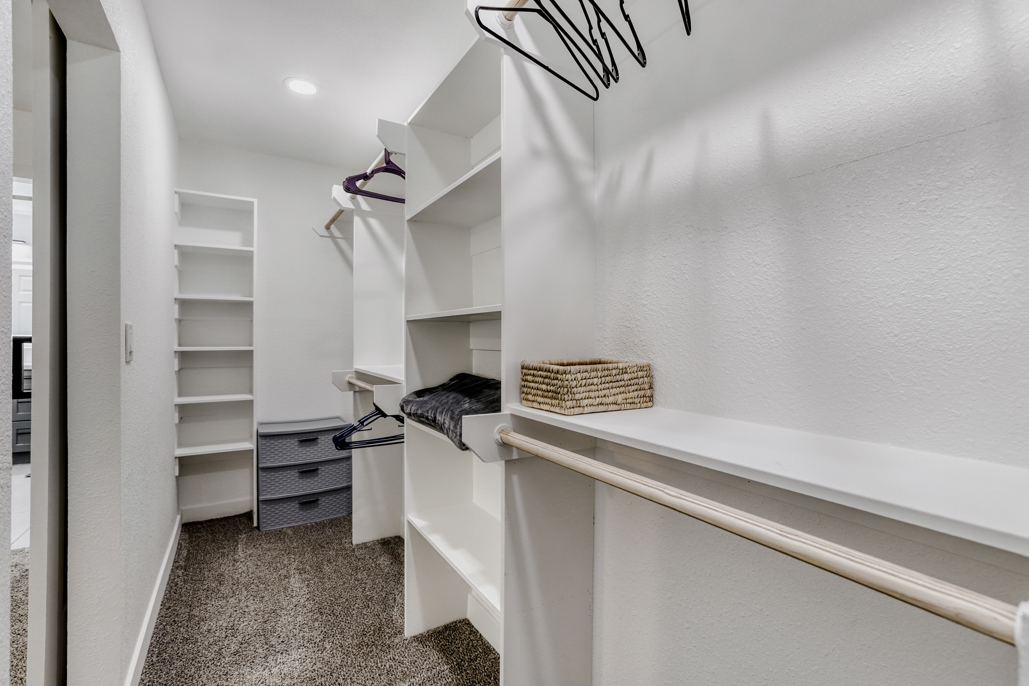 Spacious walk-in closet with built-in shelves, drawers, and hanging space