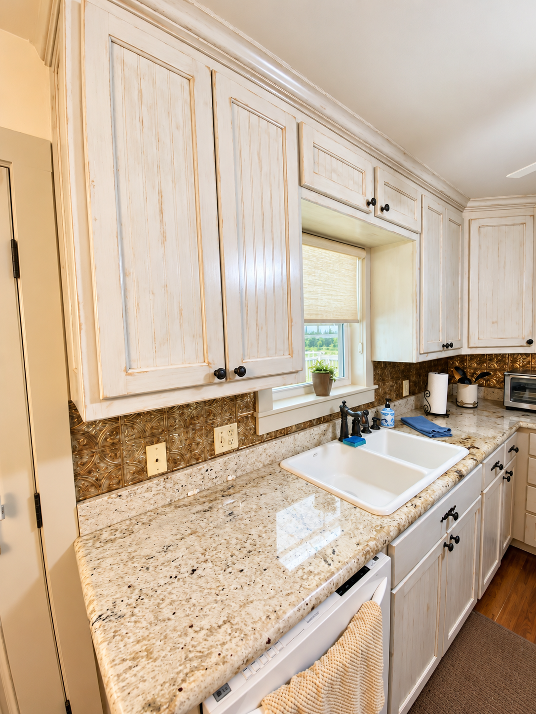 Bright kitchen with granite counters, farmhouse sink, and ample storage