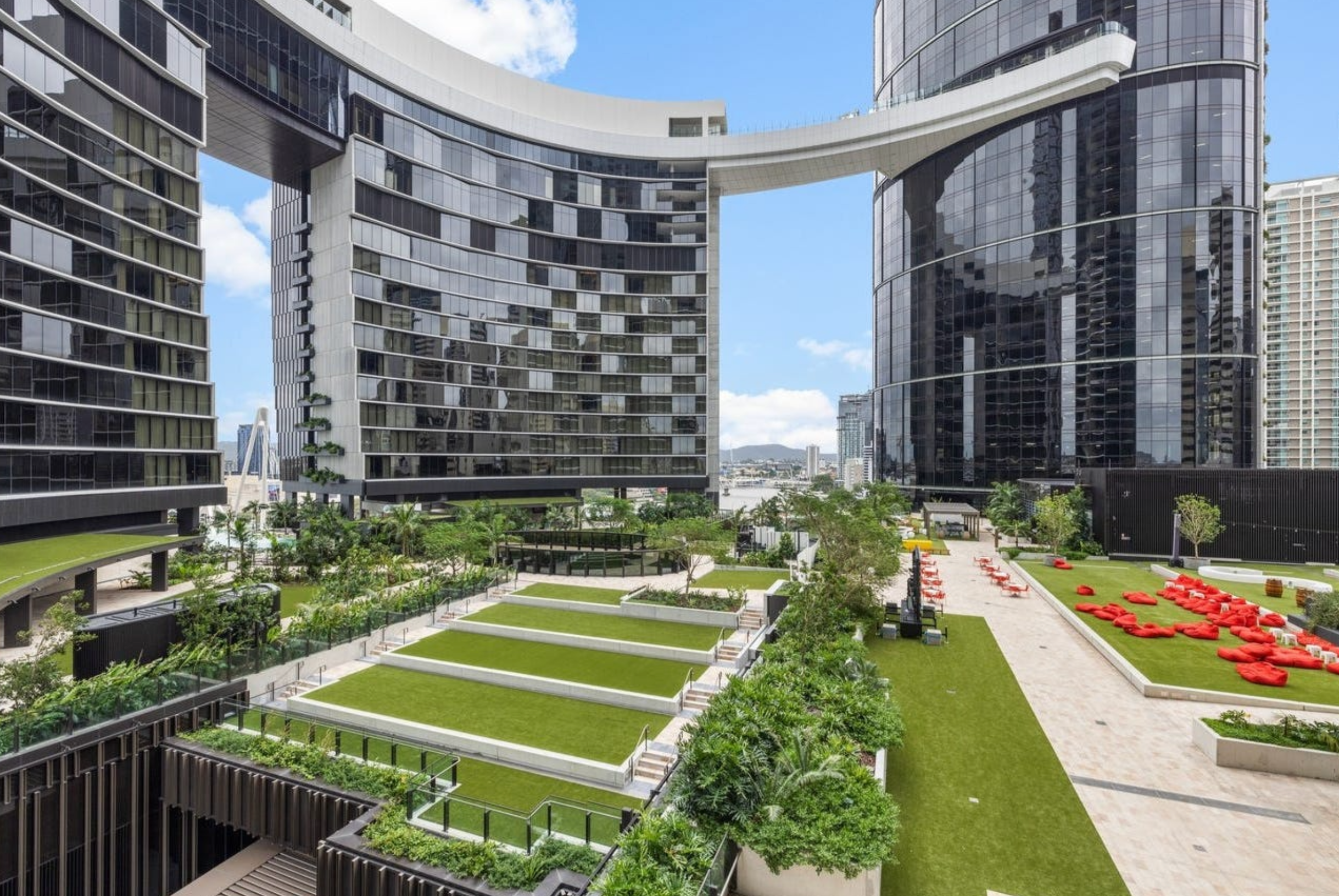 Resort-style courtyard with lush lawns and striking modern skyline views