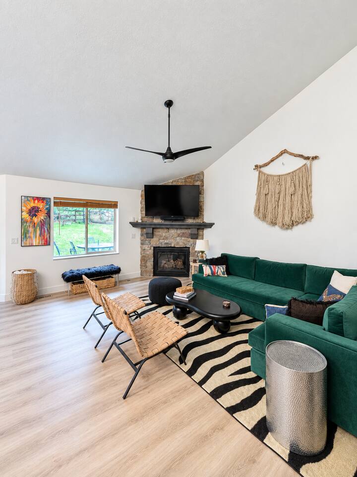 Spacious main level living room with comfortable seating, gas fireplace, 65" Roku TV, and Sonos Soundbar with a view of the backyard.