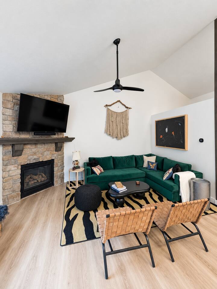 Spacious main level living room with comfortable seating, gas fireplace, 65" Roku TV, and Sonos Soundbar.