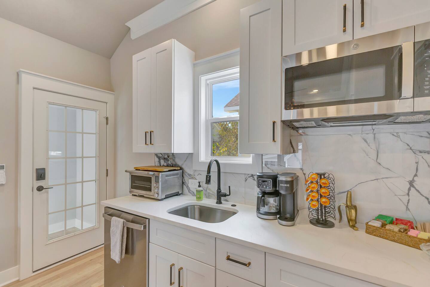 Cute kitchenette with coffee maker, microwave, dishwasher, full fridge, toaster,  hot plate,  and hot water kettle.
