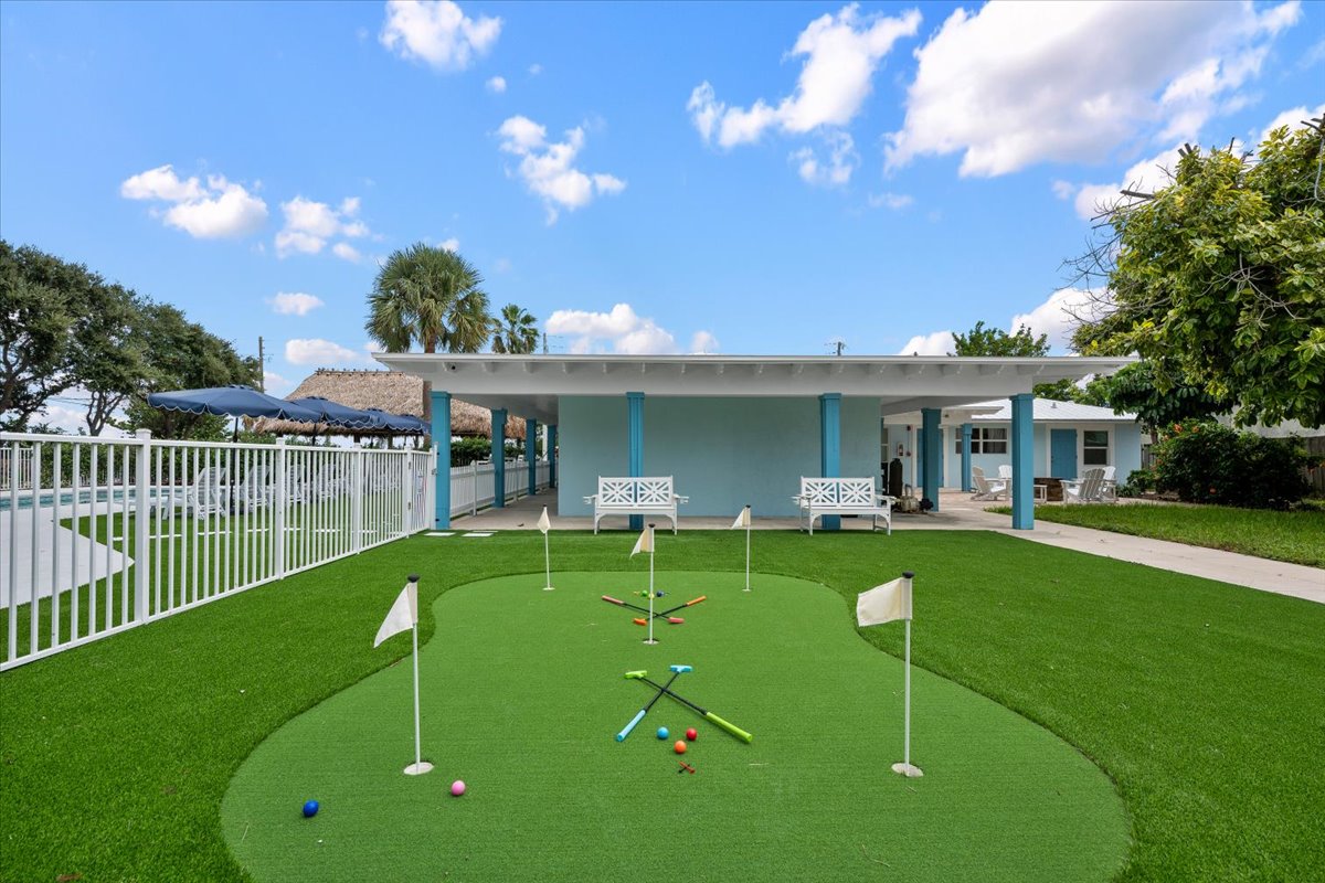 Private putting green, covered patio, and sunny resort-style backyard
